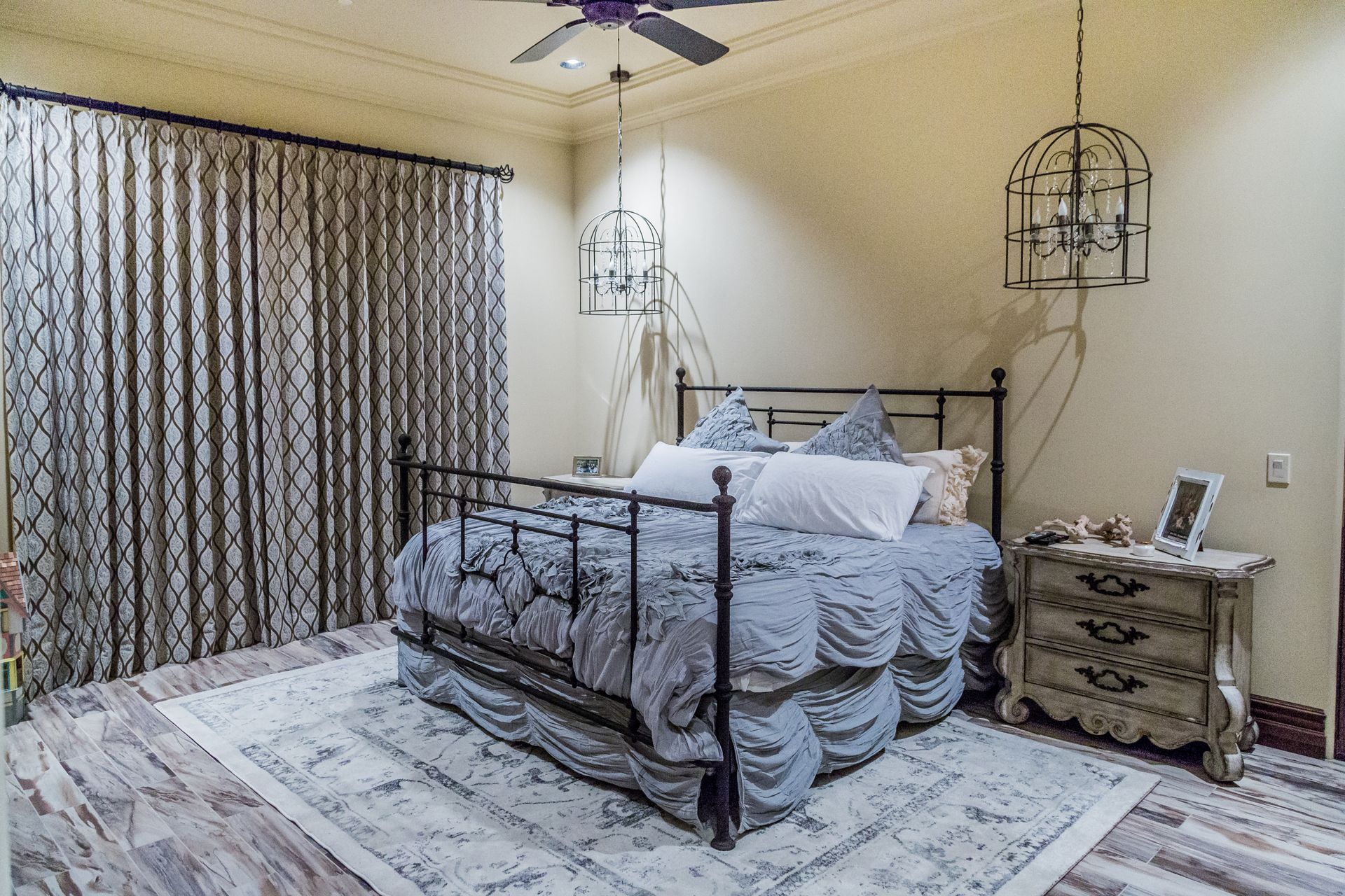 A bedroom with a bed , nightstand , rug and ceiling fan.