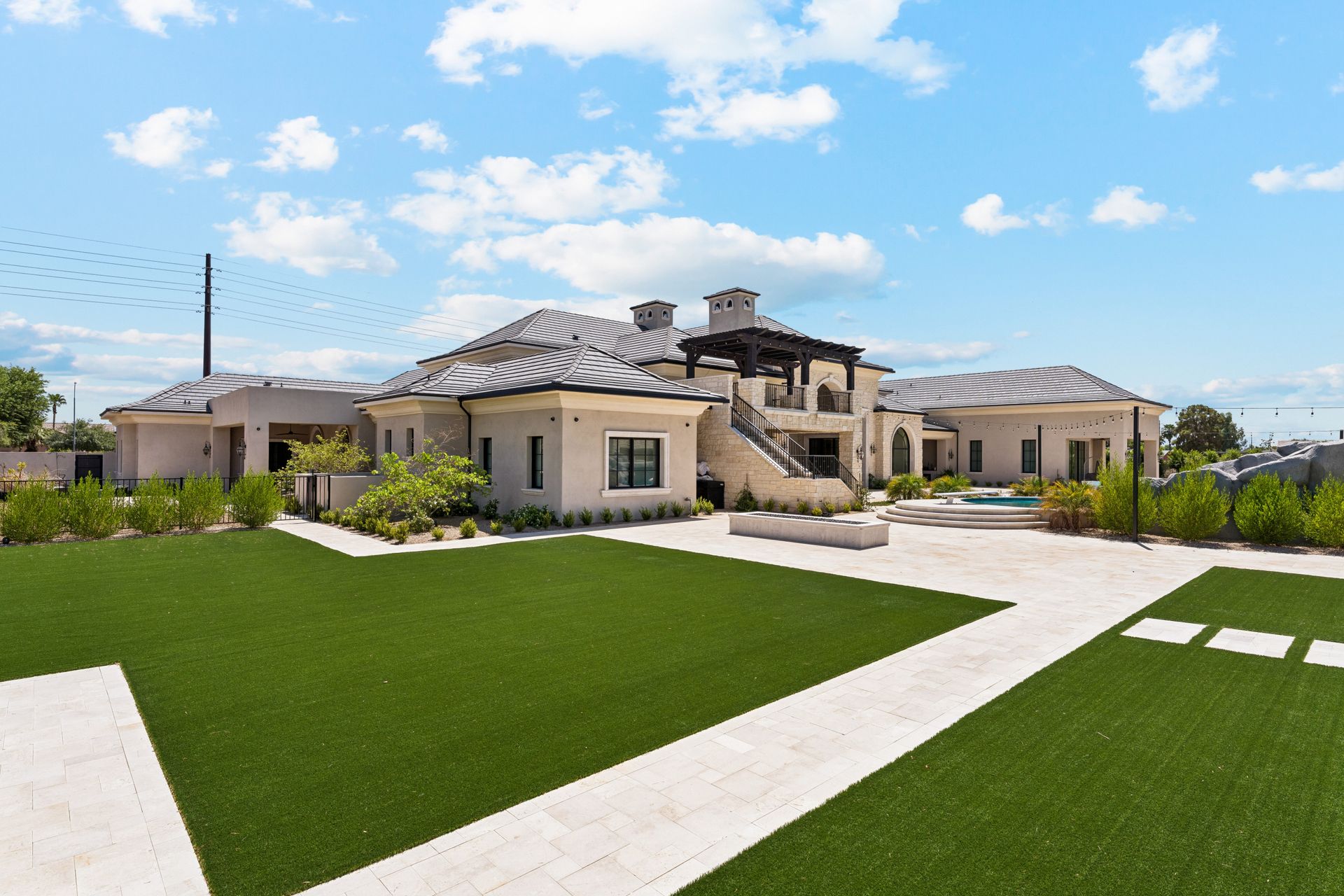 Luxury house with manicured green lawn, basketball court and walkway