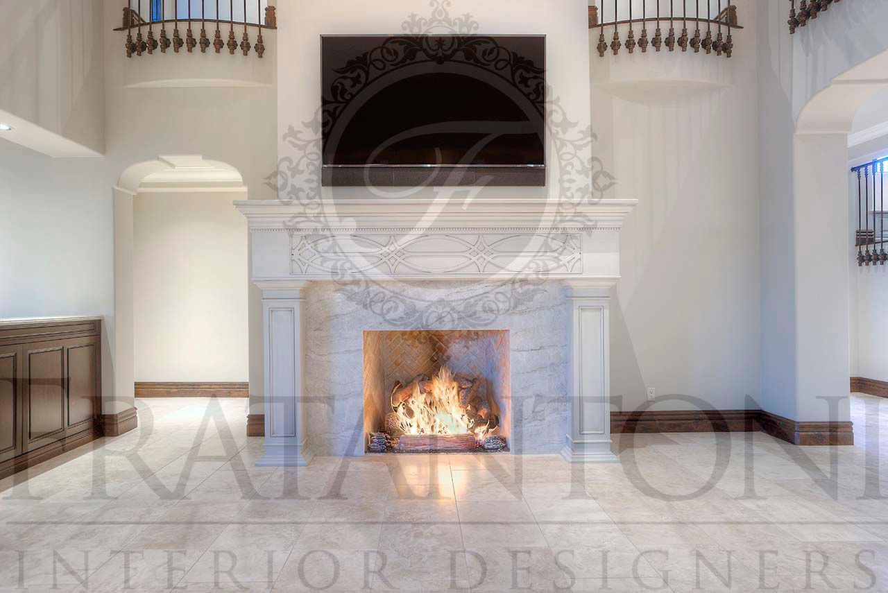 Elegant white living room with ornate marble fireplace and a lit fire beneath a carved mantel and built in TV display