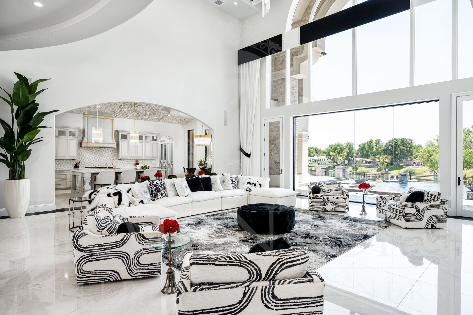 Luxury living room with white walls, large windows, a backyard view, and black and white patterned furniture designed by fratantoni interior designers in scottsdale, arizona