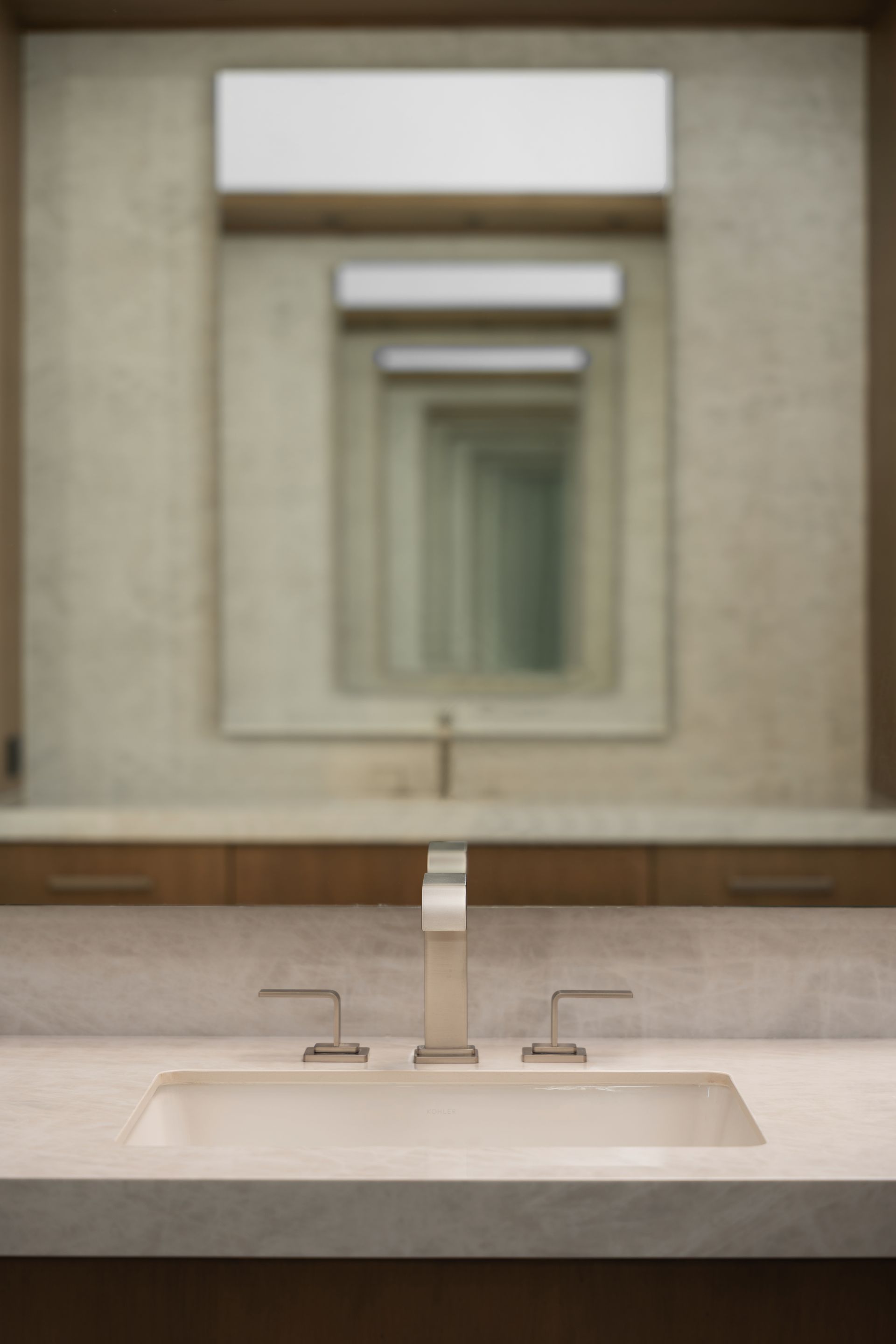 Bathroom with a sink and multiple mirrors creating an infinite reflection effect.