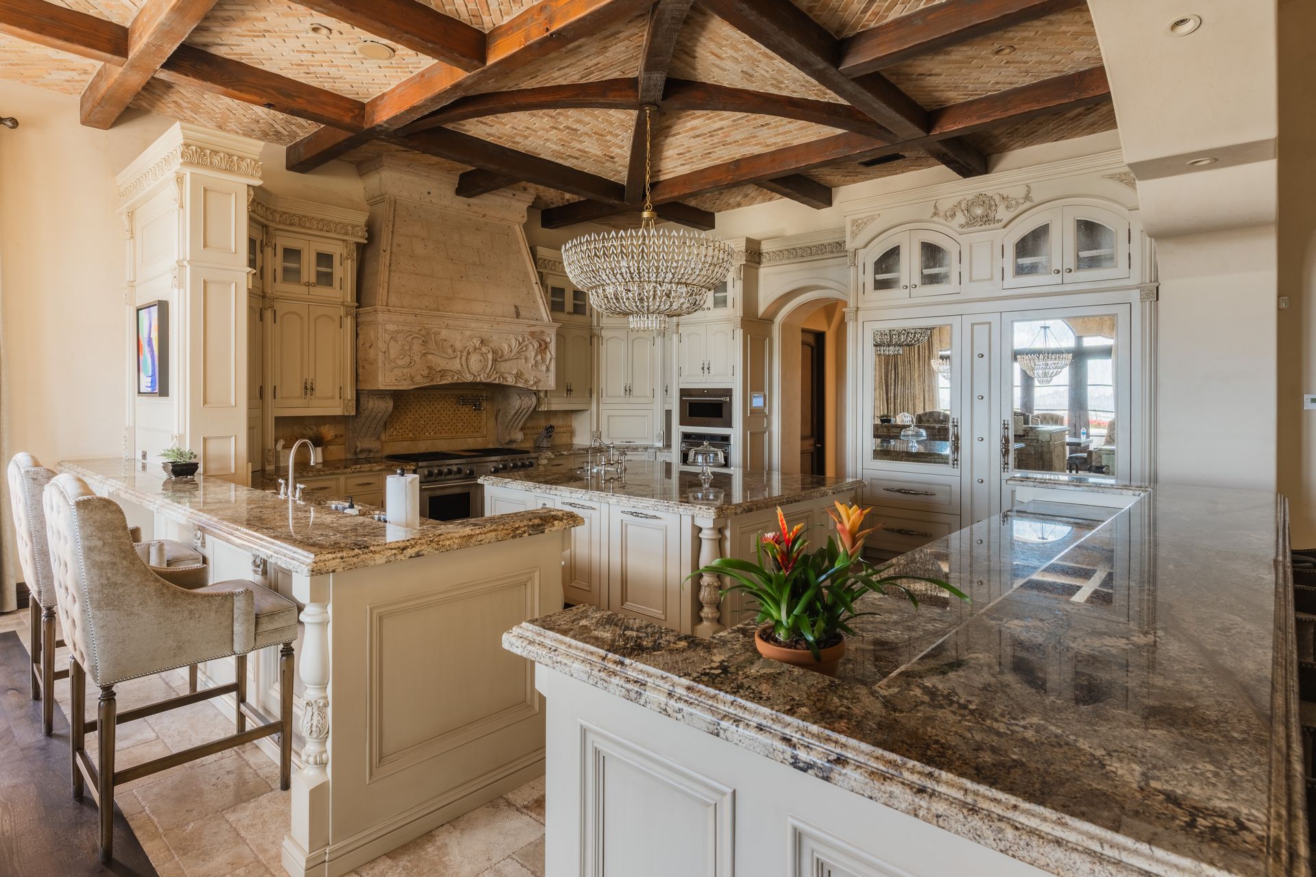 Elegant kitchen with cream cabinets, granite countertops, and wood-beam ceiling.