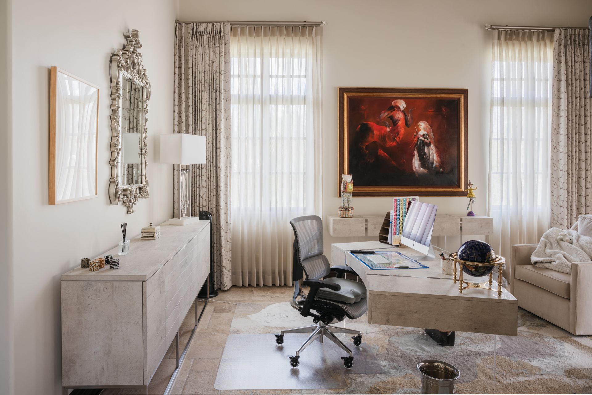 Elegant home office with desk, art, and patterned curtains.
