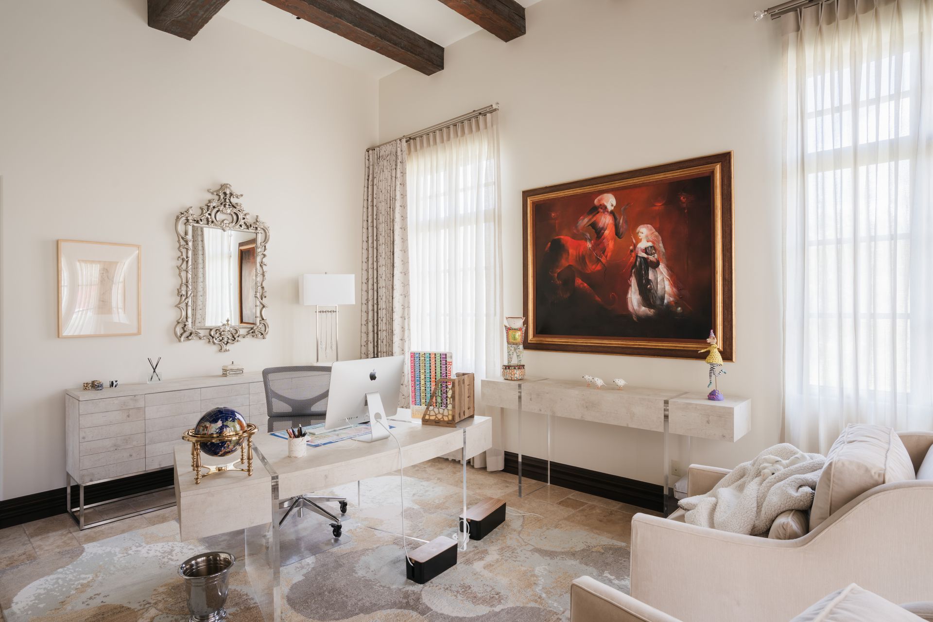 Bright home office with white walls, a large painting, and a desk.