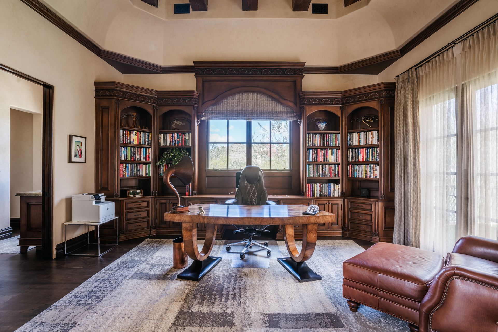 Luxurious wood-paneled office with a large desk, bookshelves, and leather seating; window with a view.