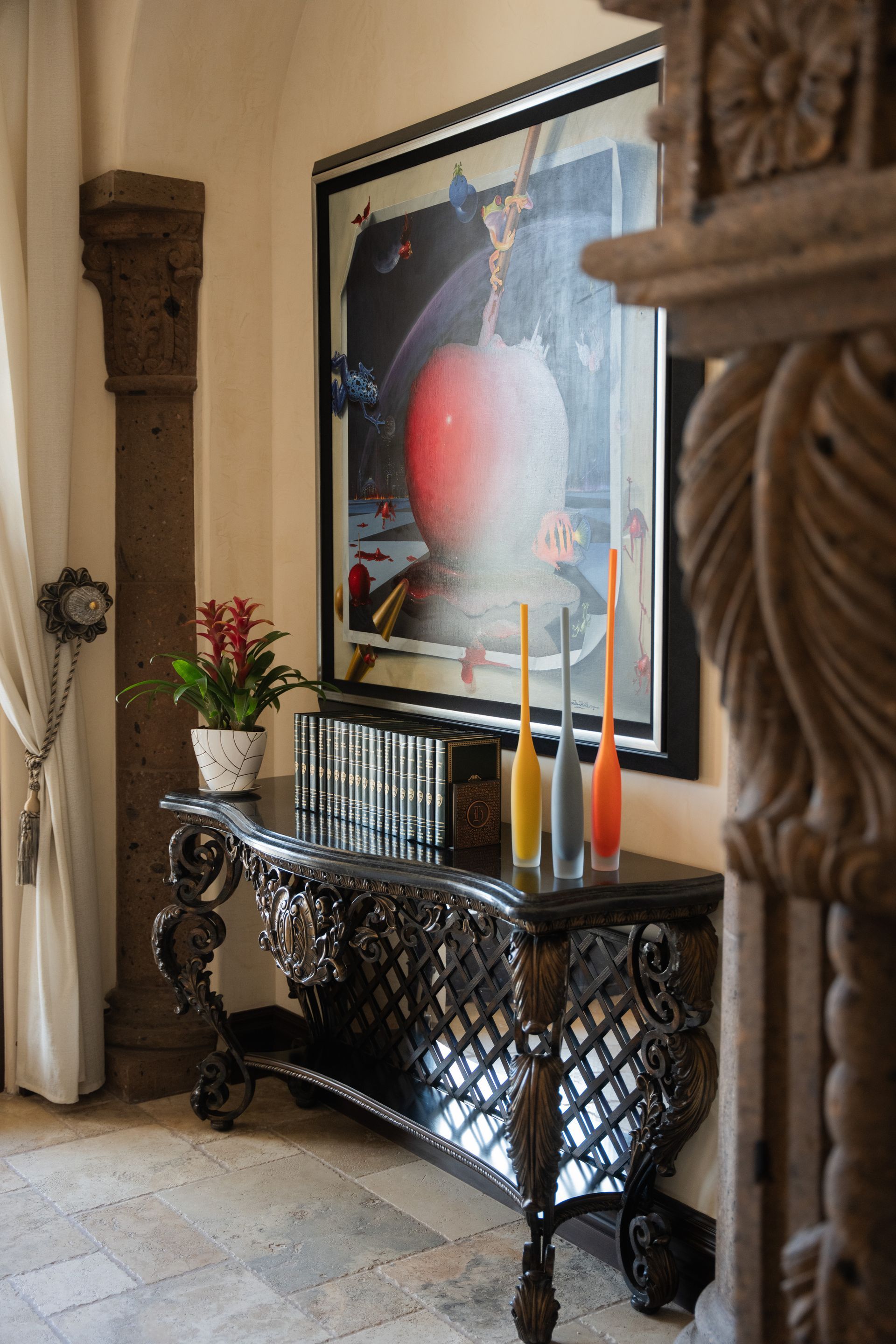 Ornate console table with art and decor in a hallway.