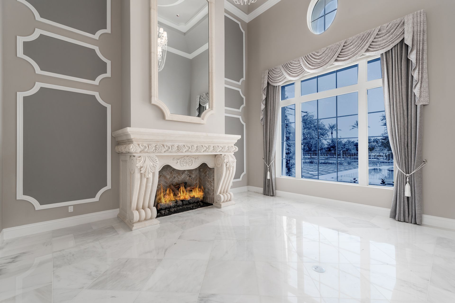 Luxurious living room with fireplace, marble floors, and large window overlooking a snowy landscape.