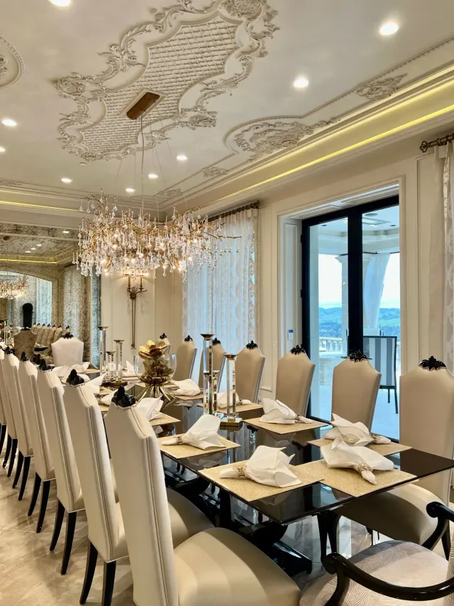 French estate kitchen design with architectural detailing, custom furniture, and luxurious formal dining table.