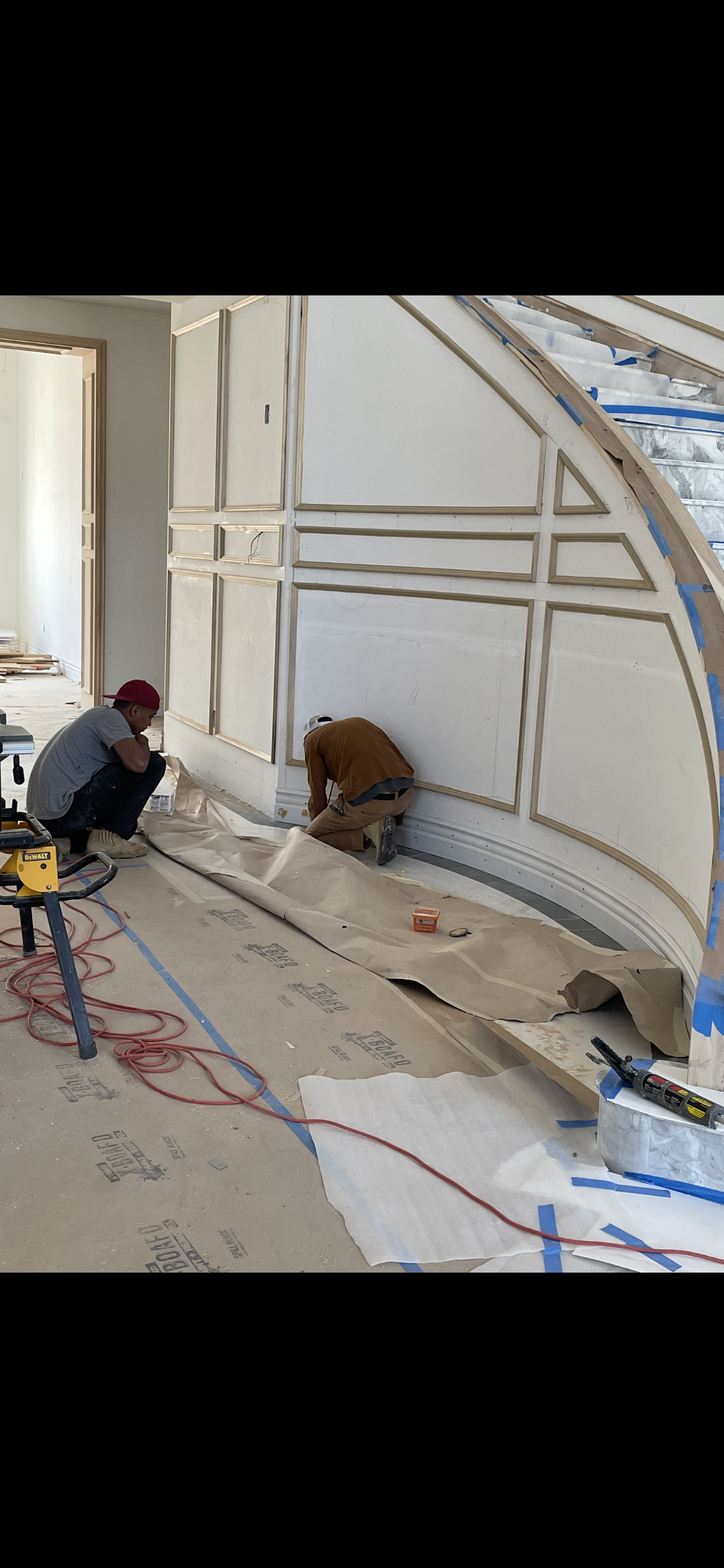 Two workers installing decorative wall panels. Construction site.