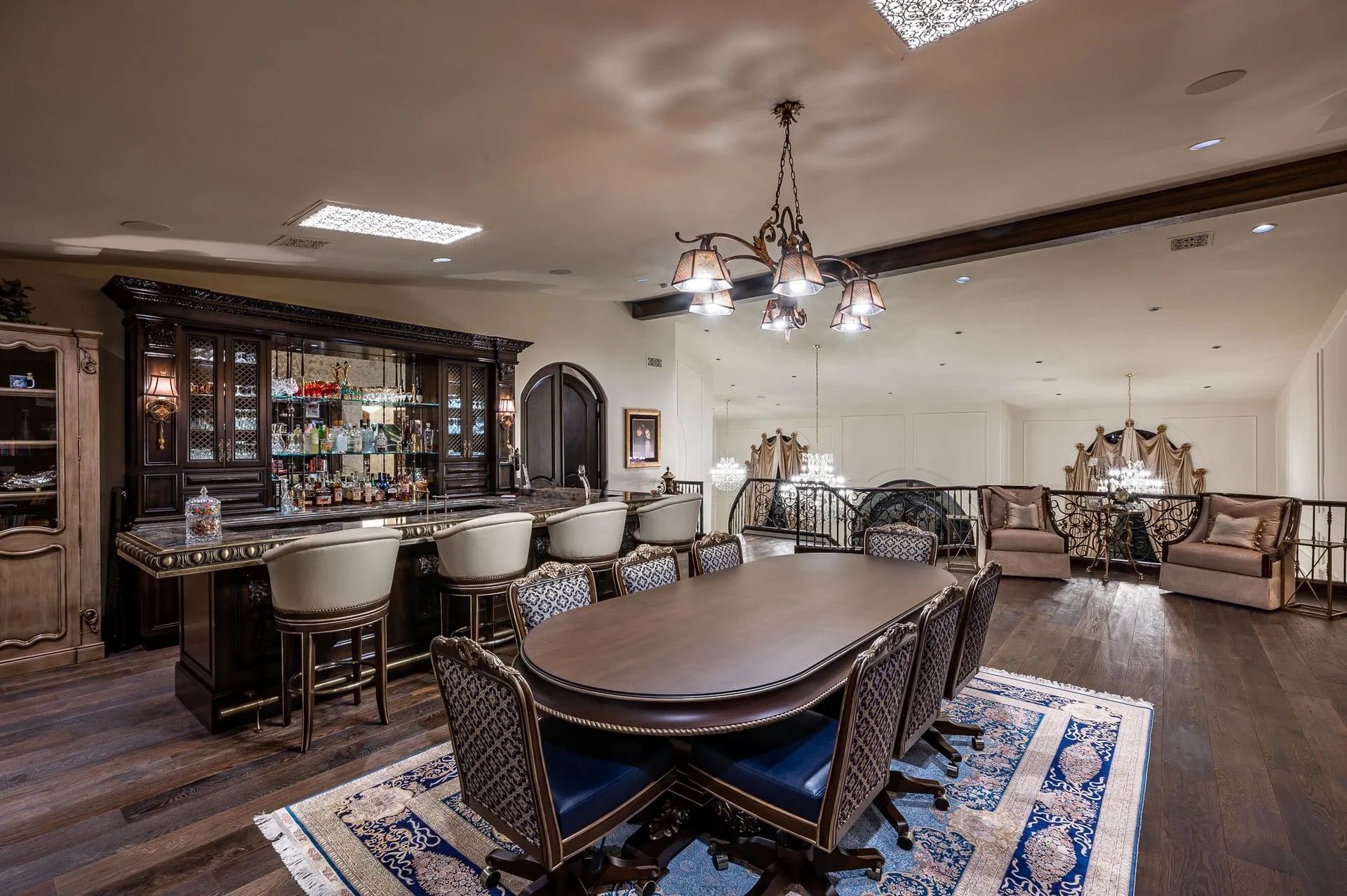 Elegant room with bar, dining table, and seating area on a mezzanine level.