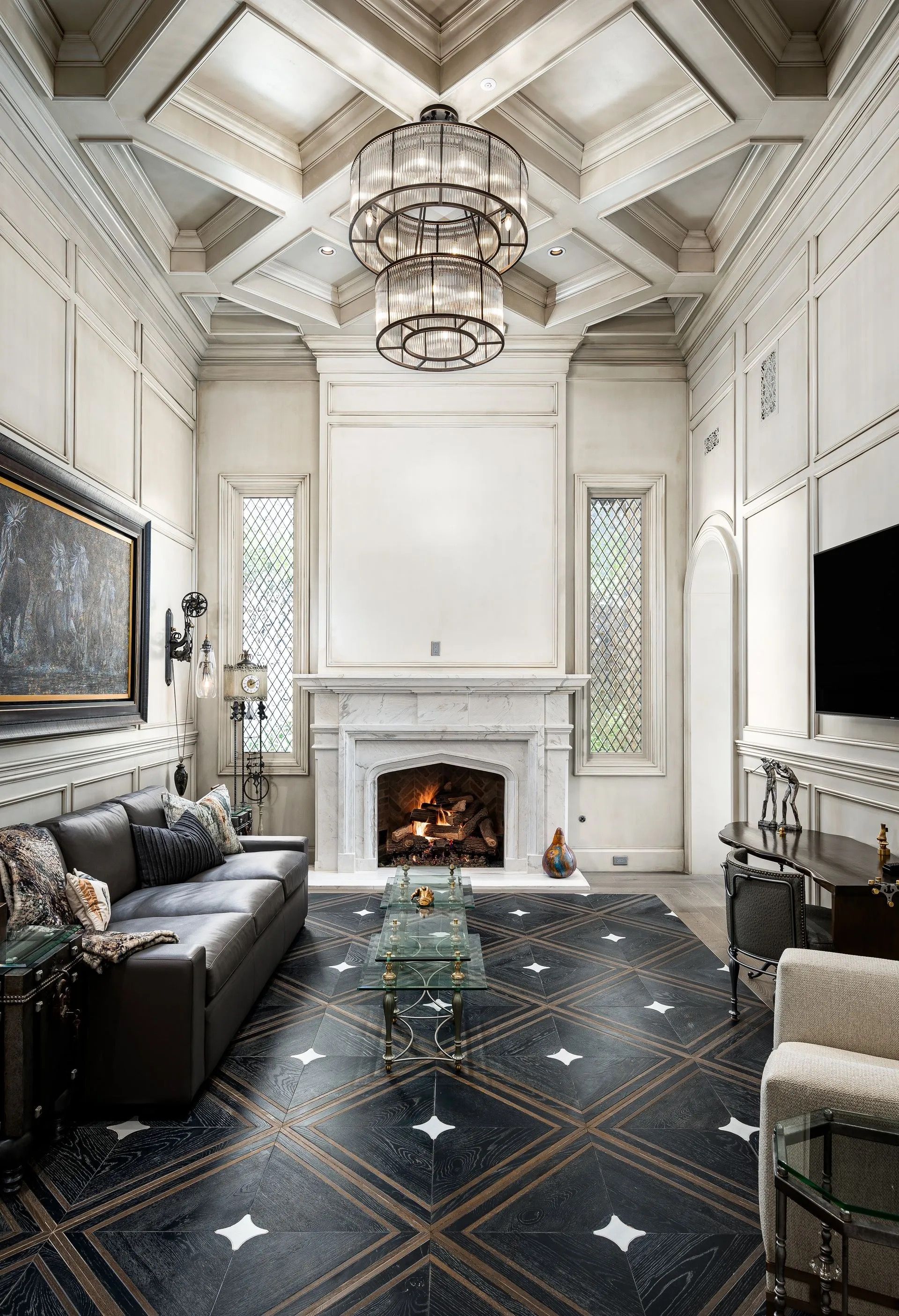 Luxurious living room with fireplace, ornate ceiling, and patterned tile floor.