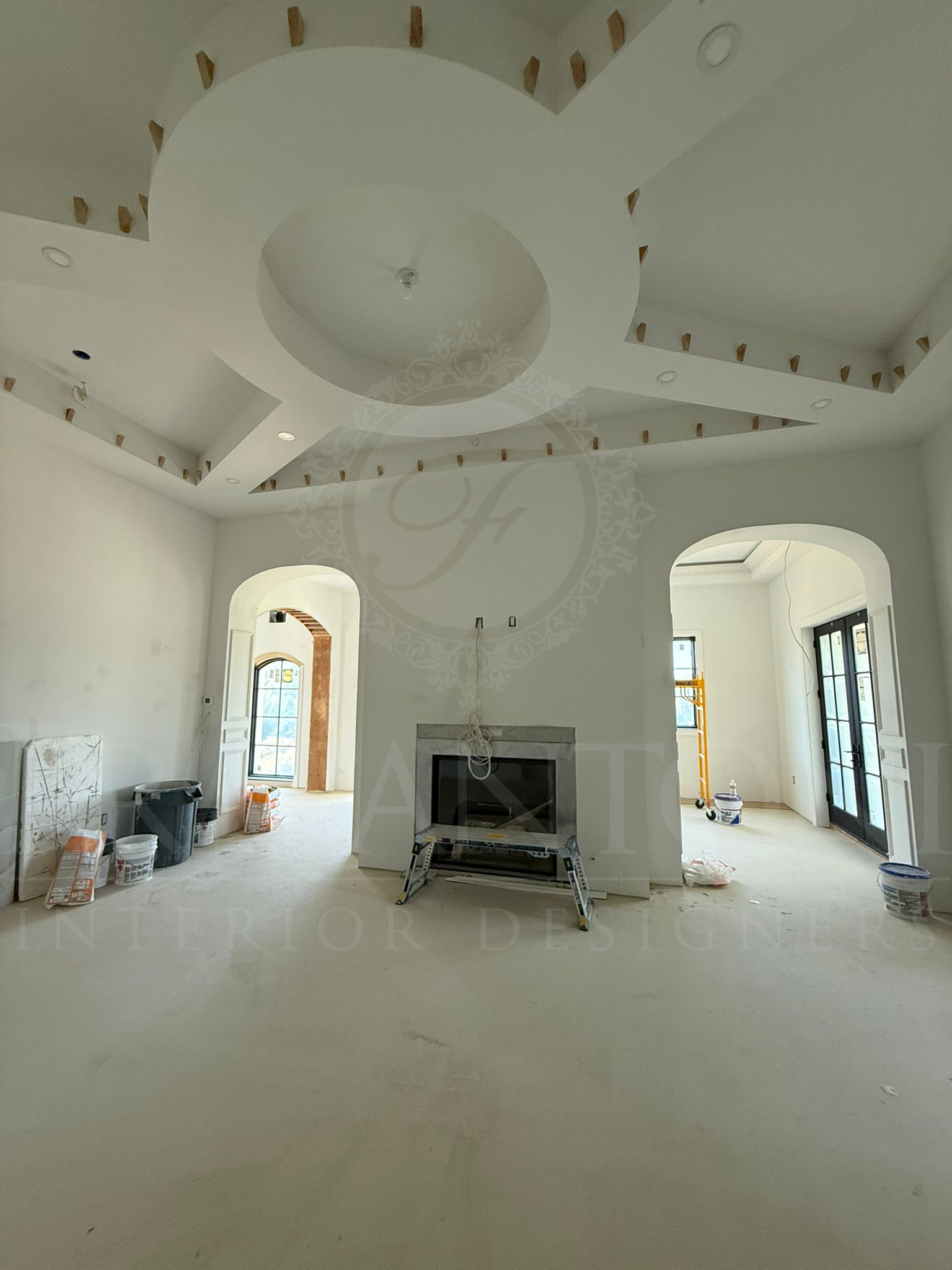 Renovation featuring a circular coffered ceiling, a central fireplace, and arched doorways leading to rooms.