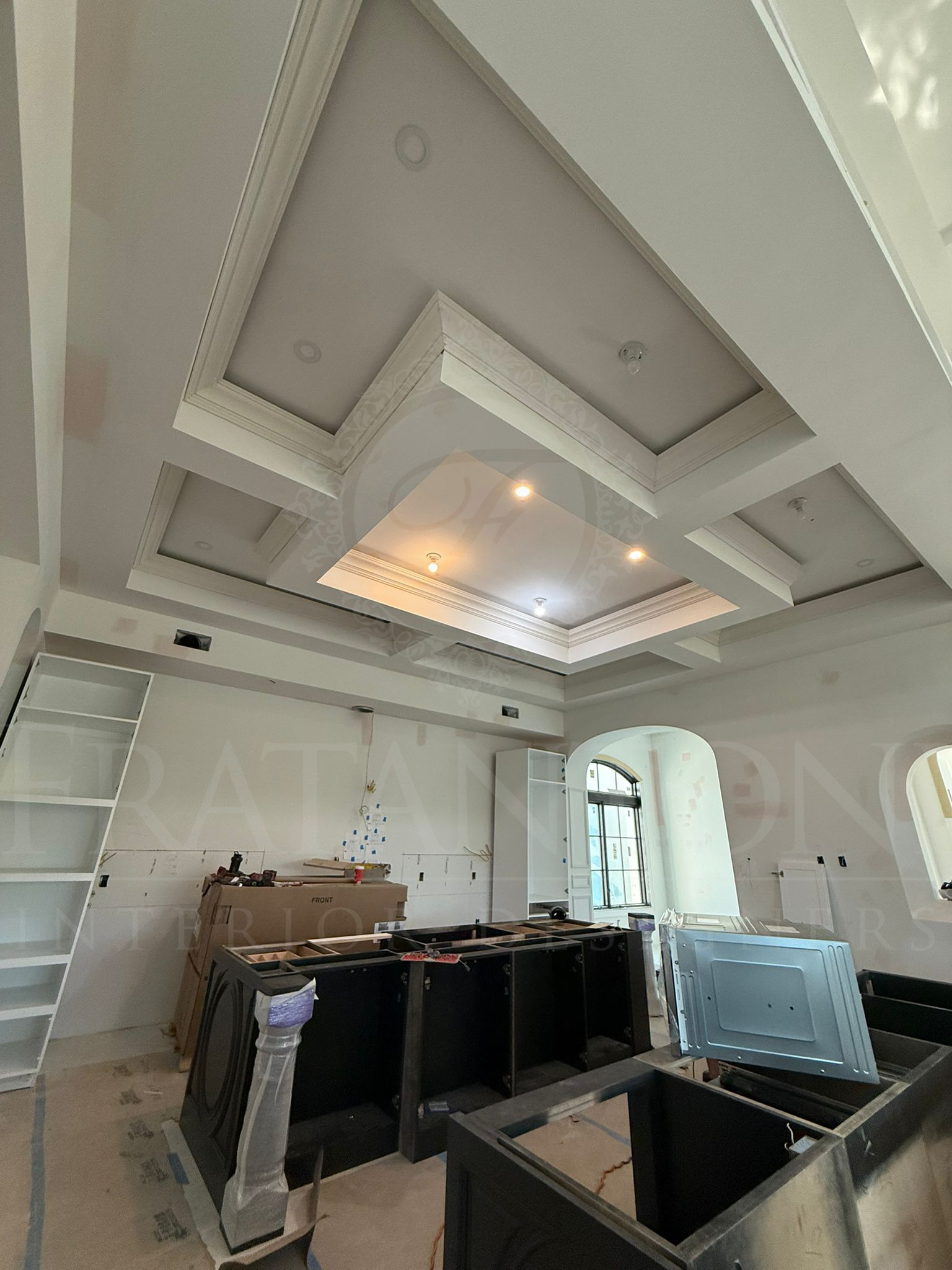 Construction featuring a white coffered ceiling with recessed lighting and a large kitchen island.