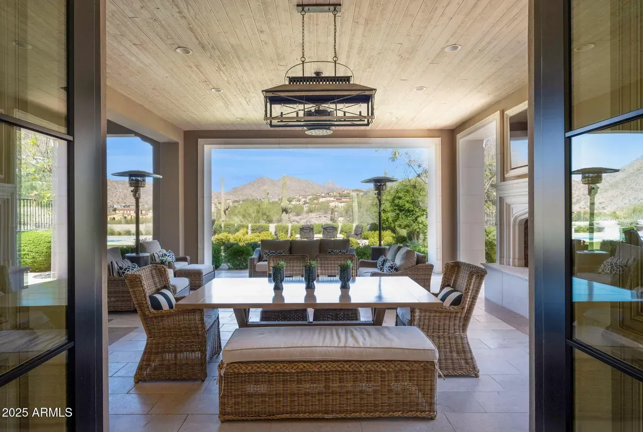 Dining room with large window overlooking patio and mountain landscape.