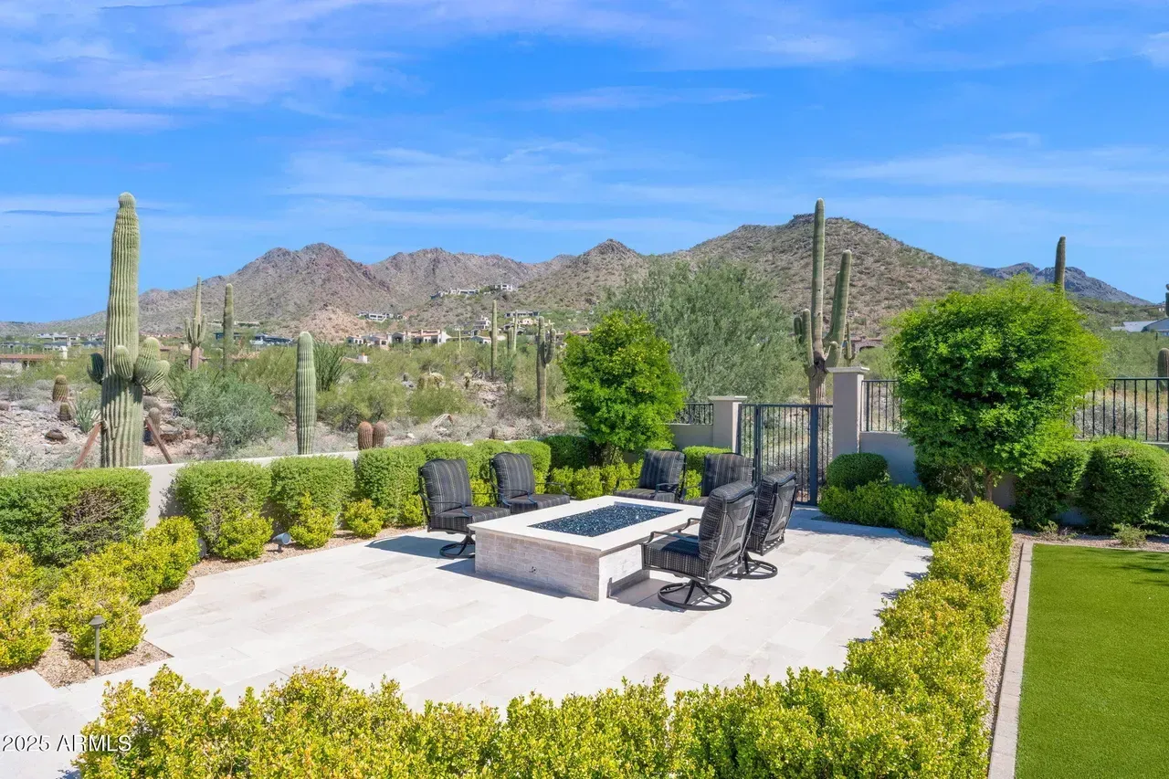 Patio with fire pit, seating, and desert mountain backdrop.