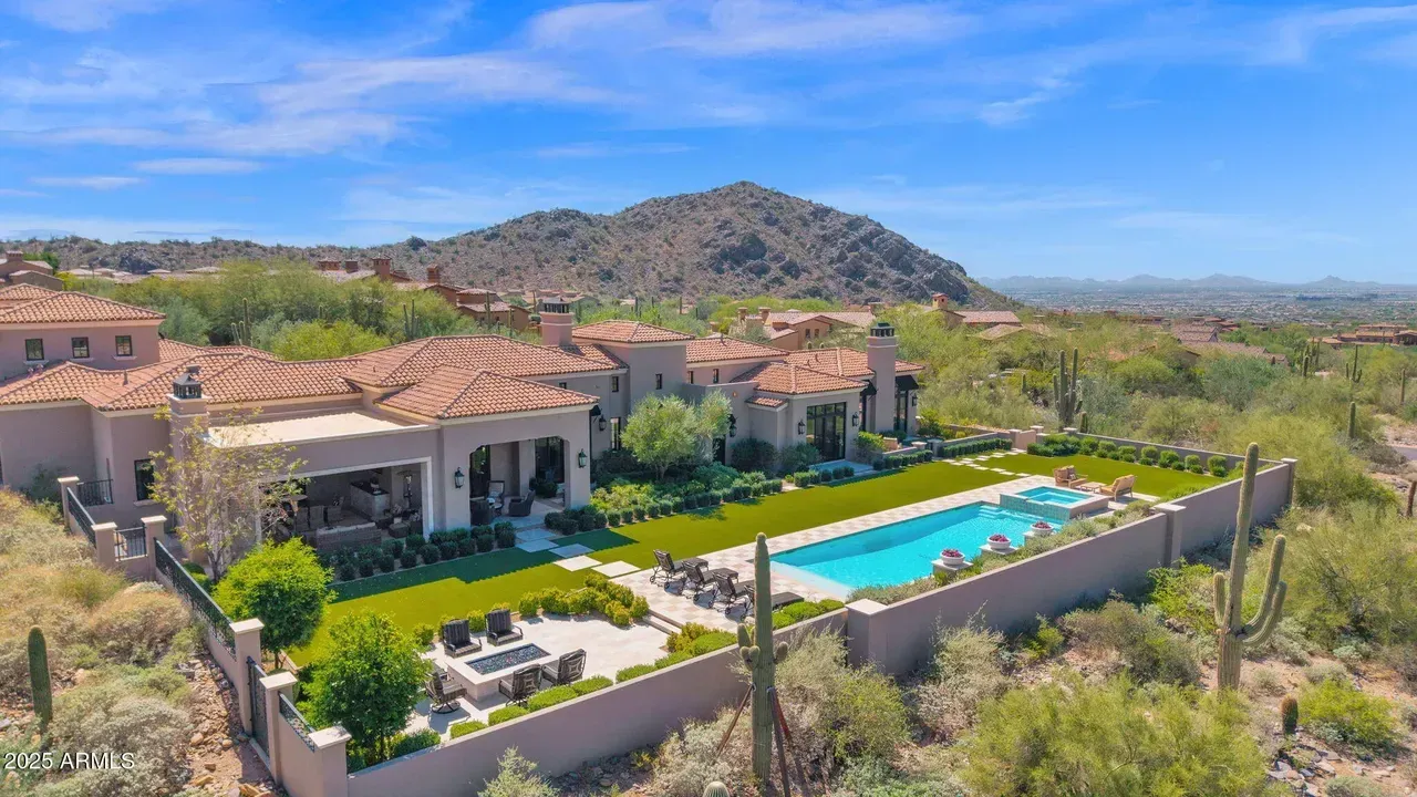 Luxury home with a pool, overlooking a desert landscape with a mountain in the background.