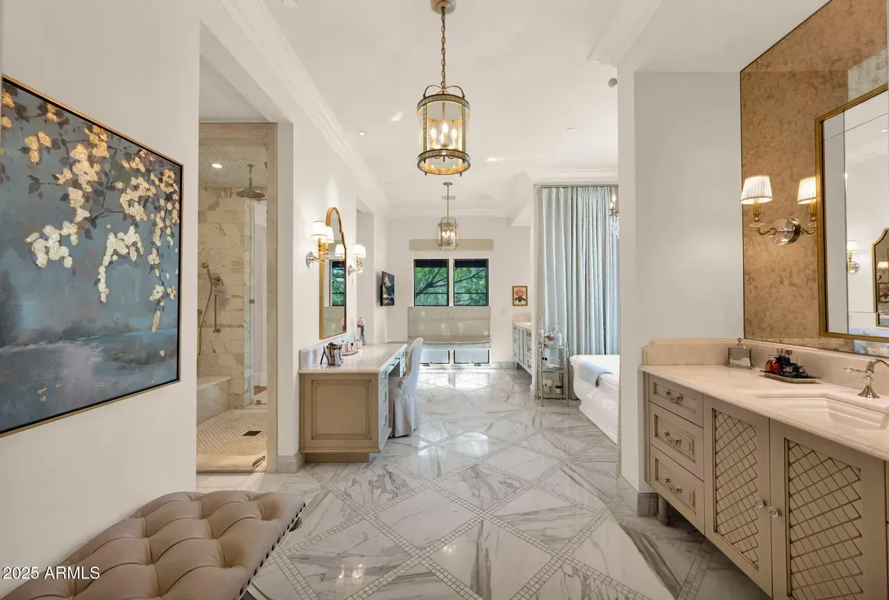 Luxurious white bathroom with marble floor, long vanity, and gold accents.