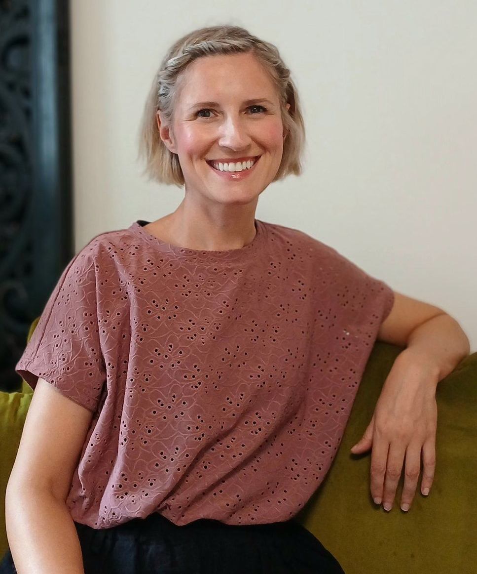 Foto von Lisa, Frau mit blonden Haaren, pinker Pulli, sitzend