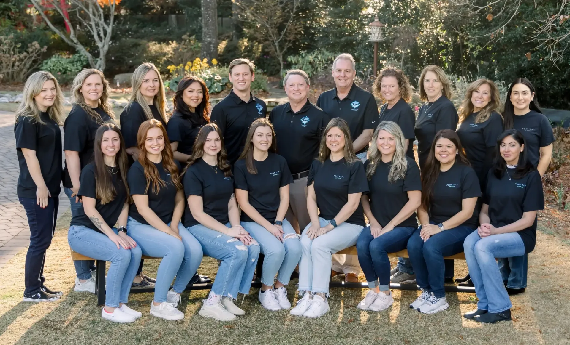 Port City Ortho staff posing for a photo in a park