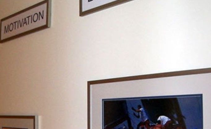 A white wall with a sign that says motivation on it