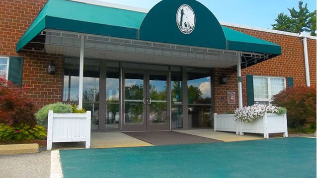 A brick building with a green awning over the entrance