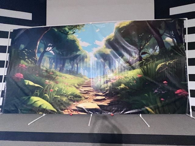 A backdrop depicting a sunlit forest path with lush greenery and flowers.
