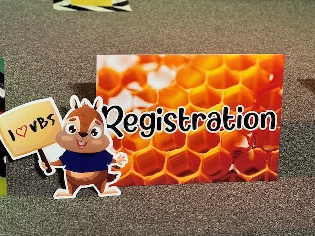 A cartoon chipmunk holding a sign that reads
