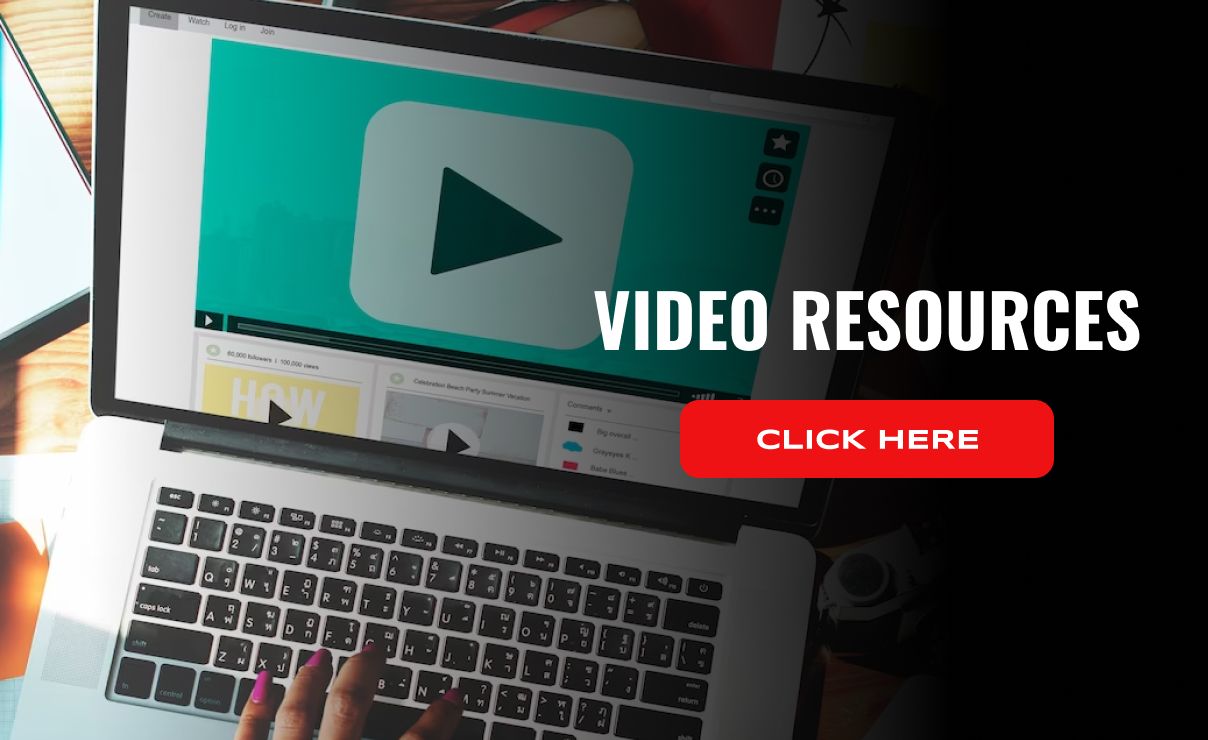 A person is typing on a laptop computer with a video on the screen.