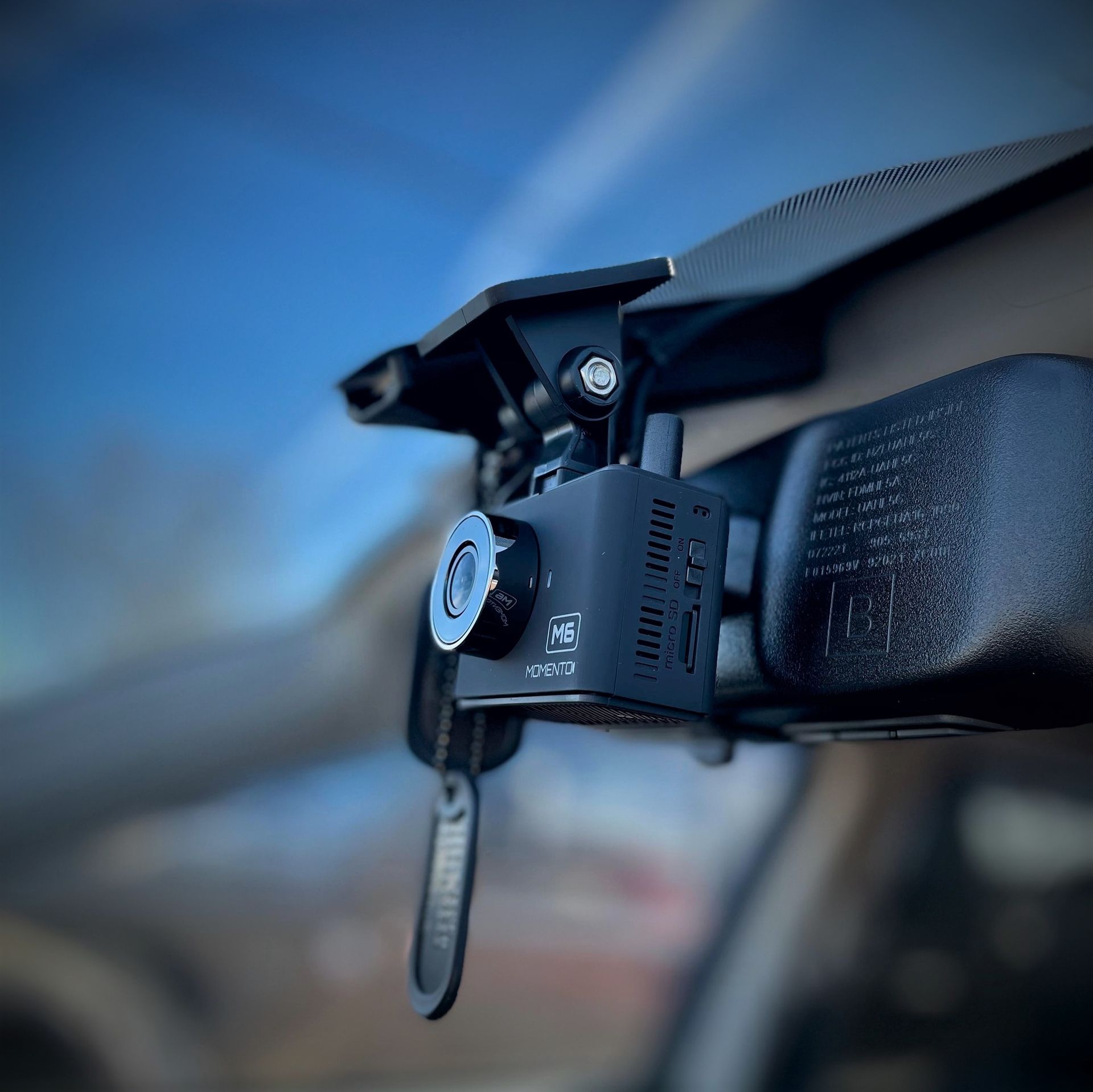 A camera mounted to the rear view mirror of a car
