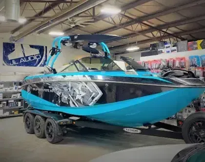 A blue and black boat is parked in a garage.