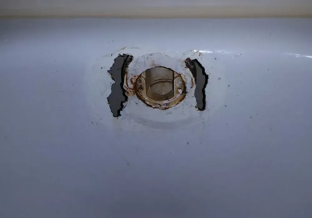 A close up of a sink with a hole in it.