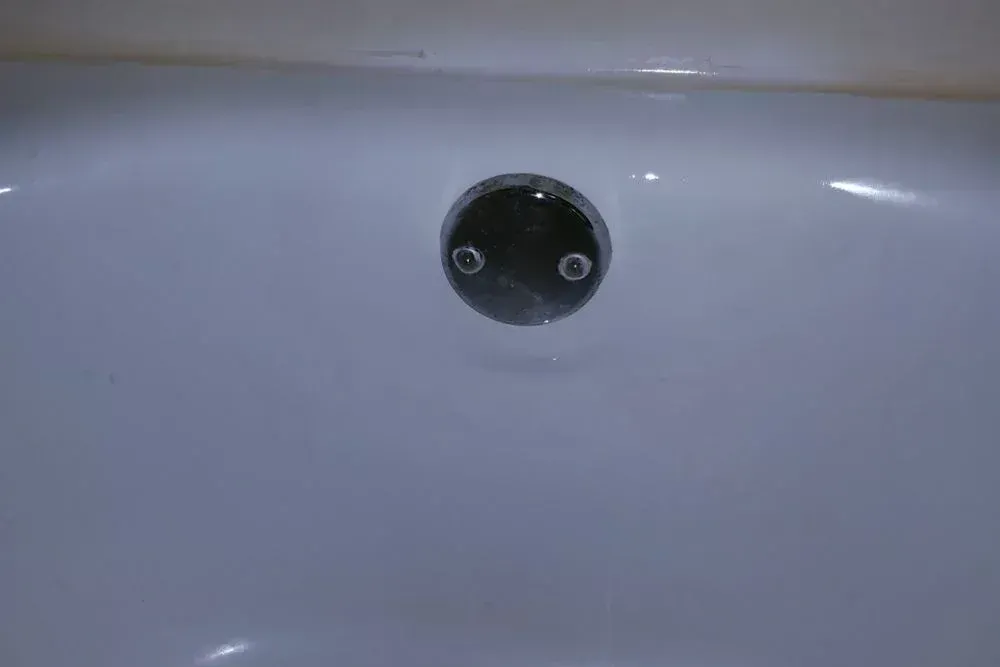 A close up of a bathtub with a drain in it.
