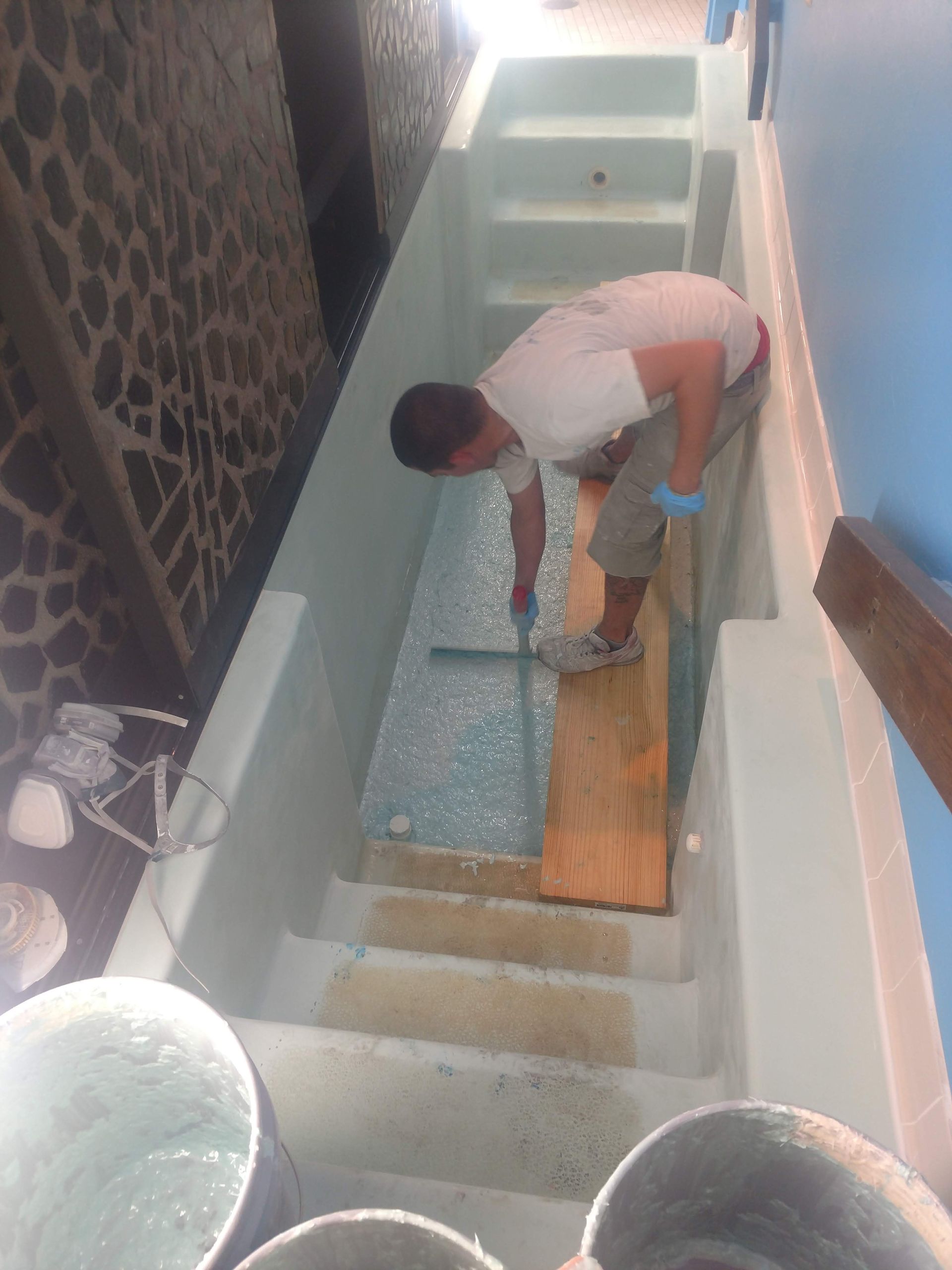 A man is working on a staircase in a pool.
