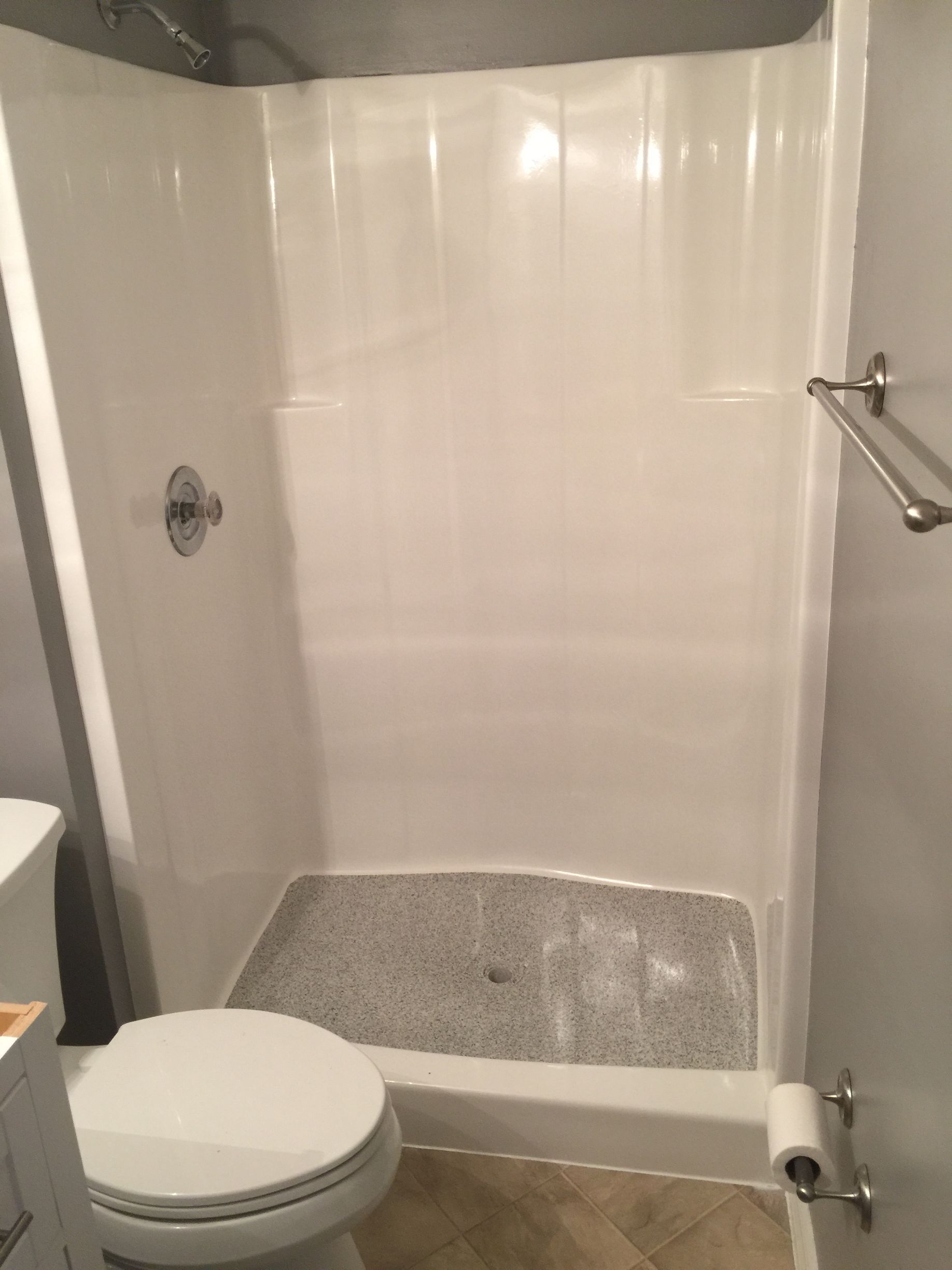 A bathroom with a toilet , sink and shower.