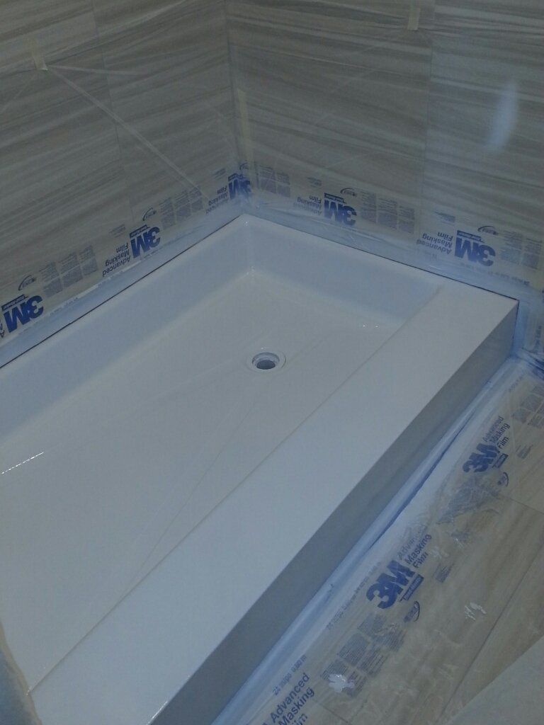 A shower stall is being installed in a bathroom.