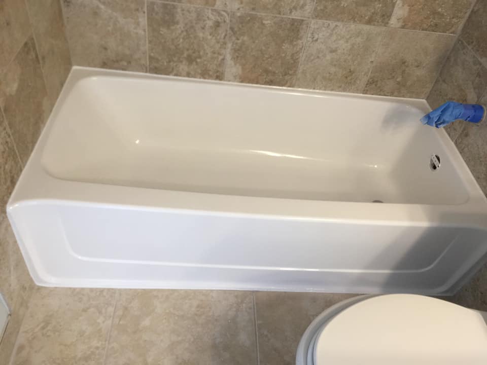 A white bathtub is sitting next to a toilet in a bathroom.