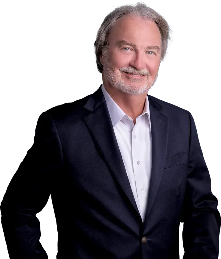 A man in a suit and white shirt is standing with his hands on his hips.