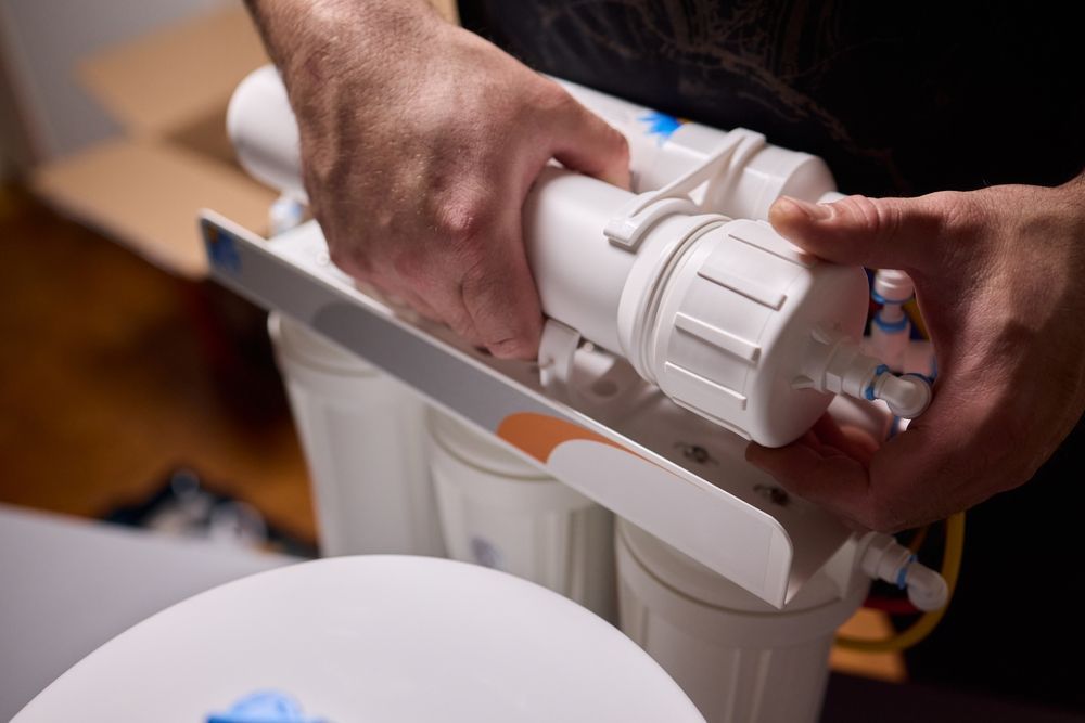 Hands adjusting a white plastic medical device on a table