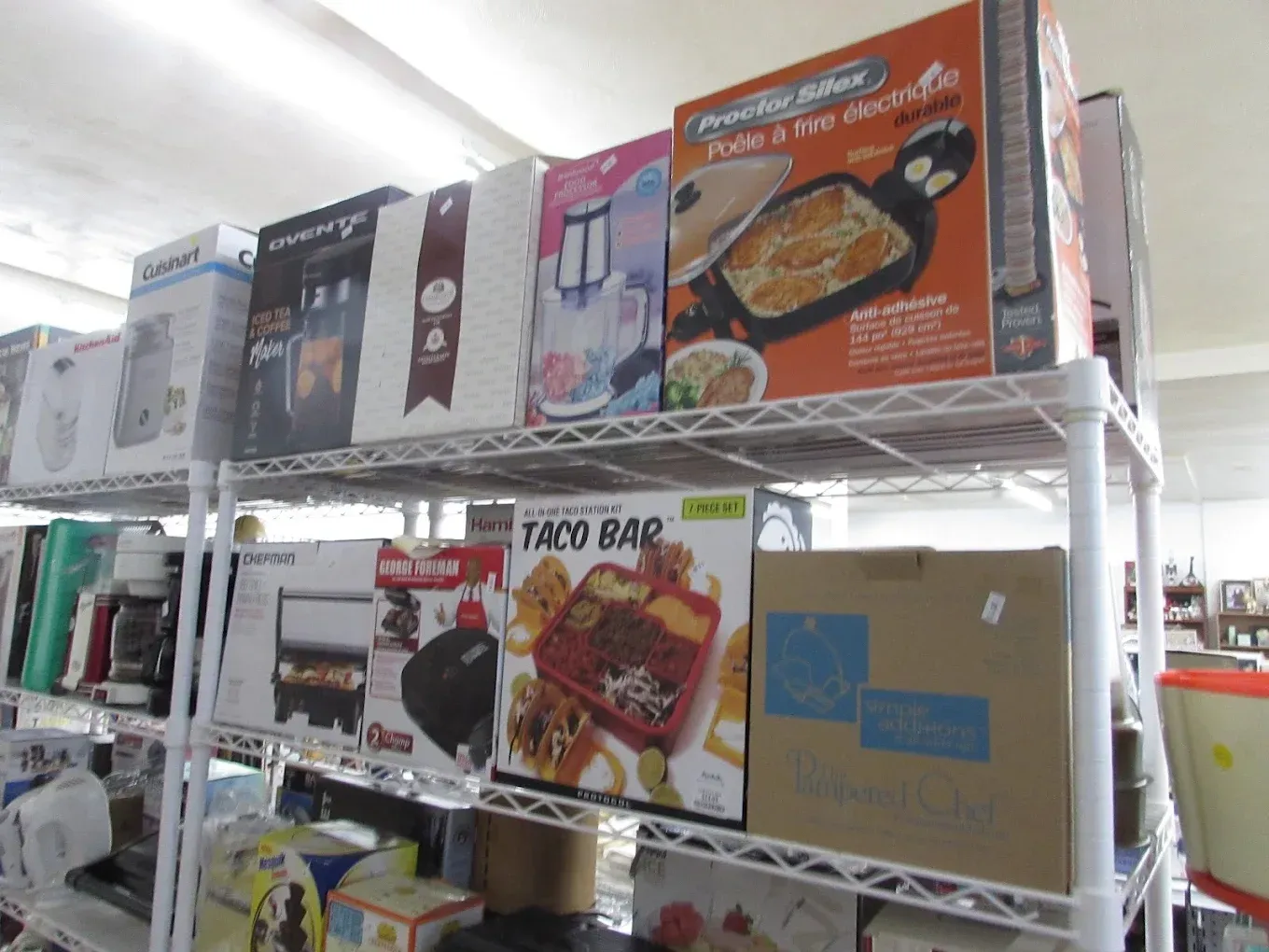 Store shelves stacked with assorted boxed food items, including taco bar kits and other packaged groceries