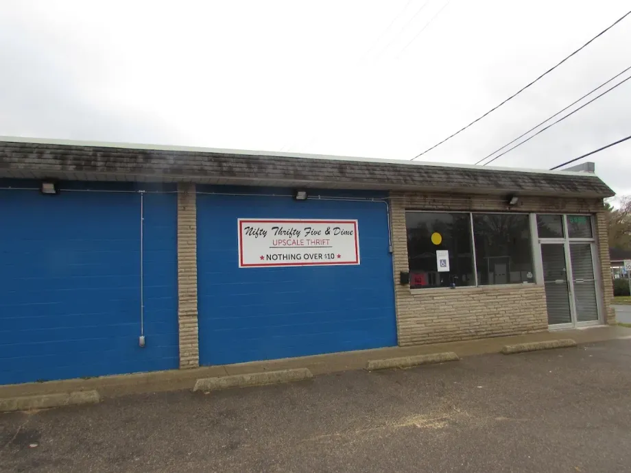 Blue storefront with a sign above the entrance and a glass door on the right