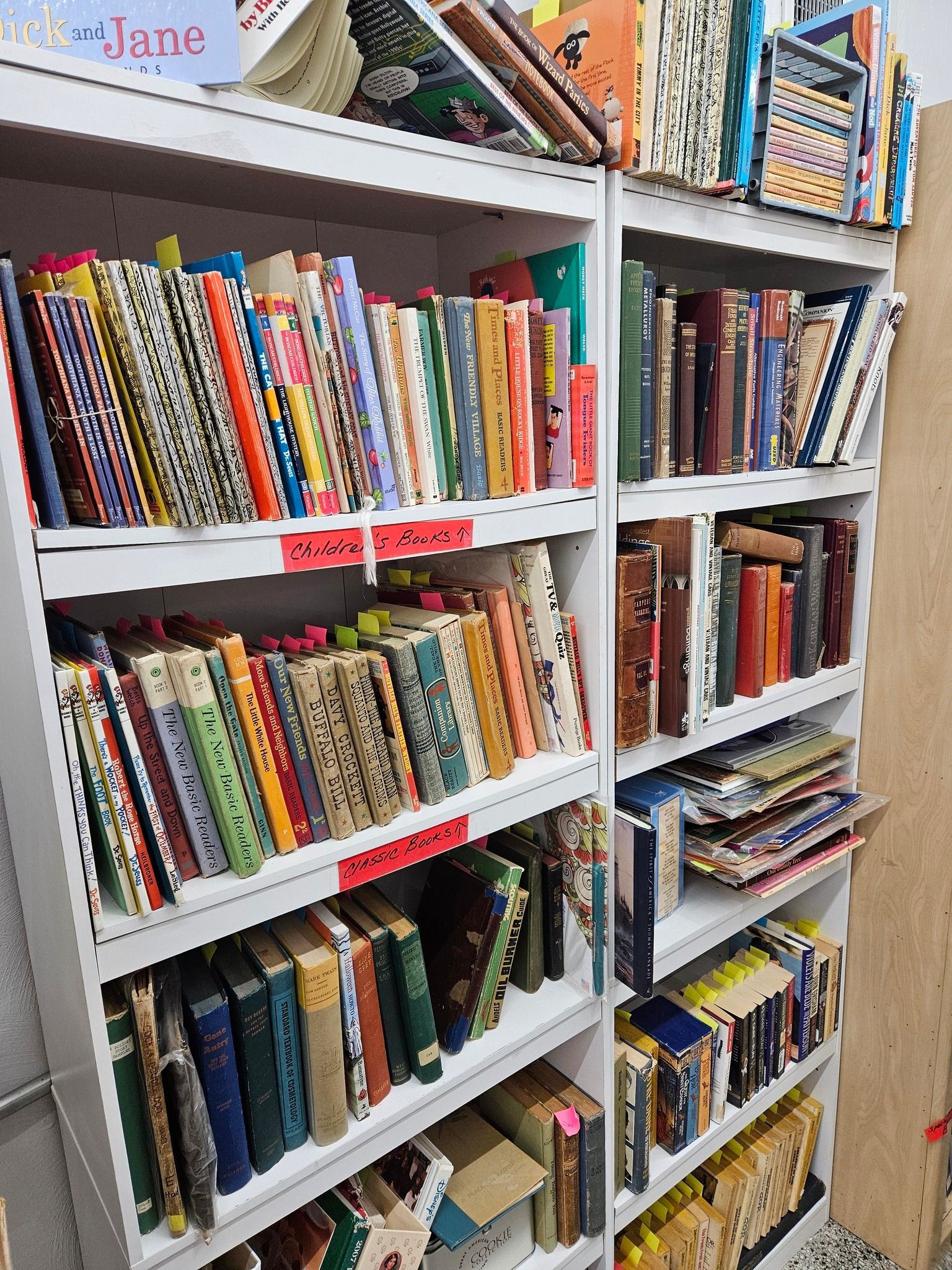 Bookshelves filled with colorful books and magazines in a narrow library aisle