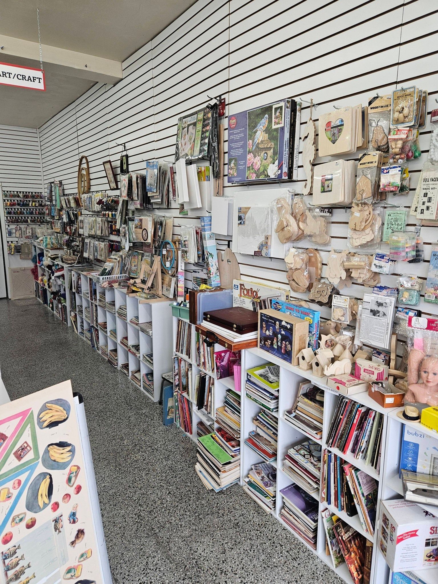 A craft store aisle with shelves of colorful stationery, stickers, and small gift items.