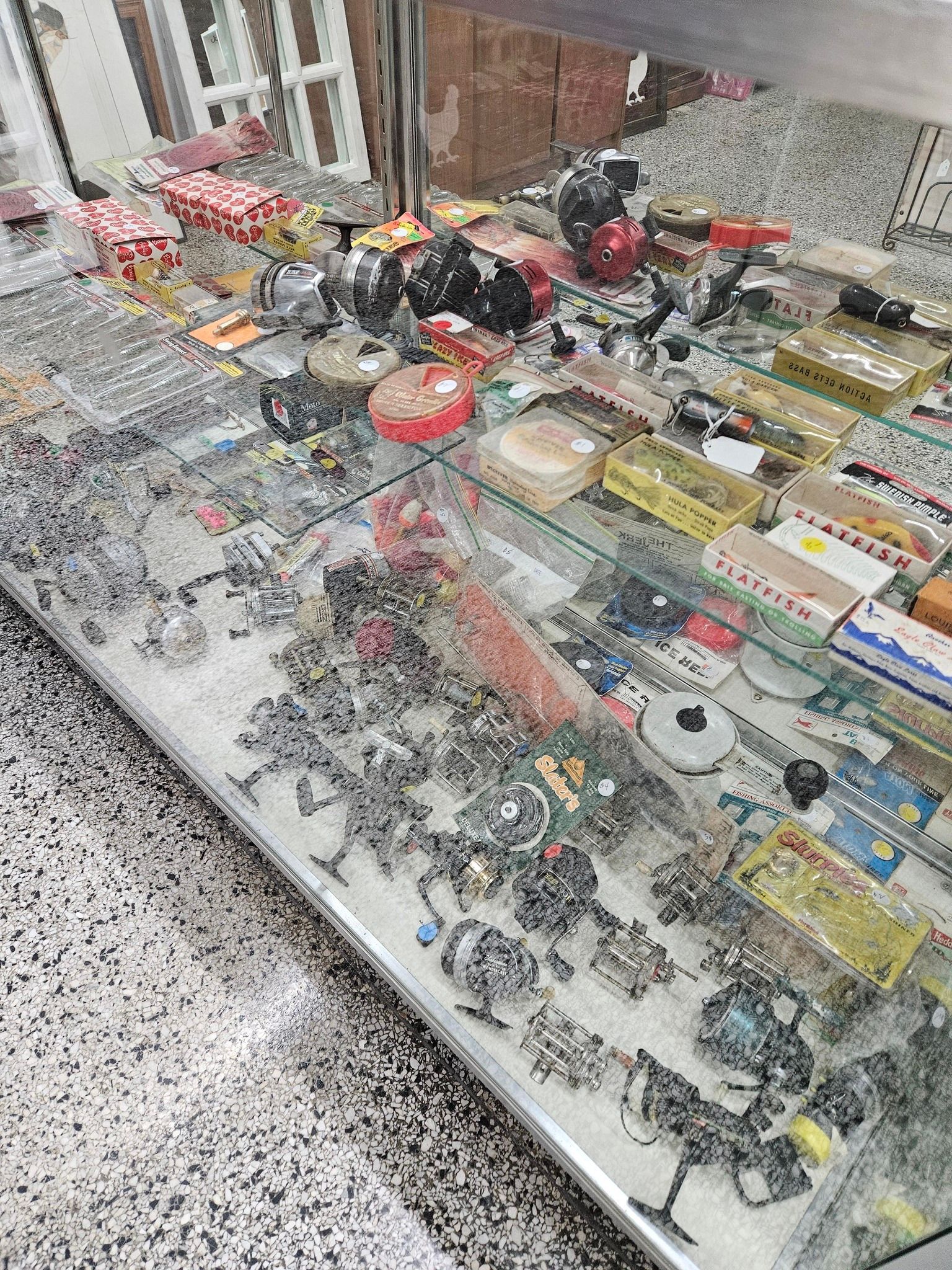 Display case filled with colorful toy vehicles, figurines, and model sets in a store.