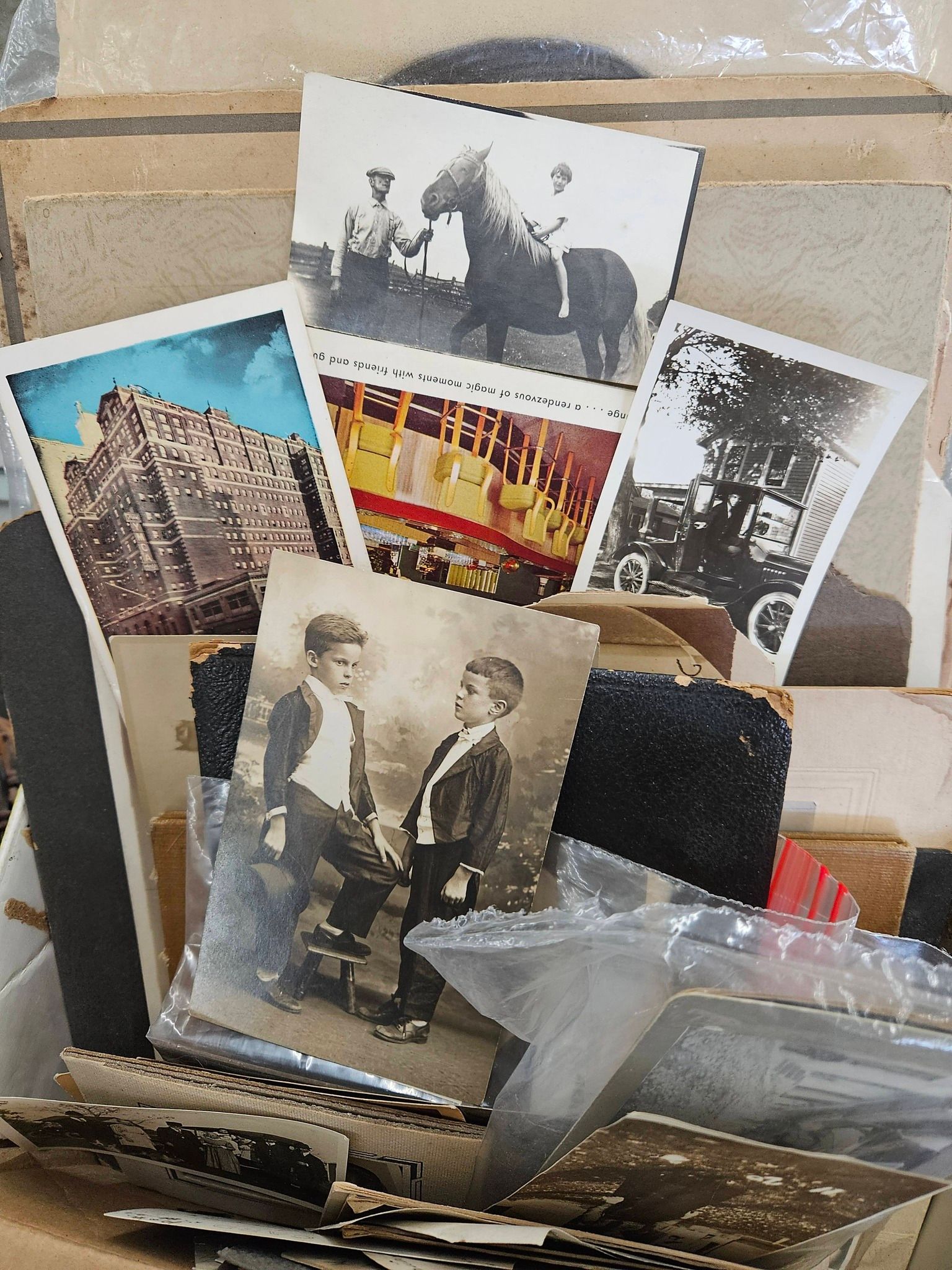 Assorted vintage black-and-white and color photographs stacked in a box or basket