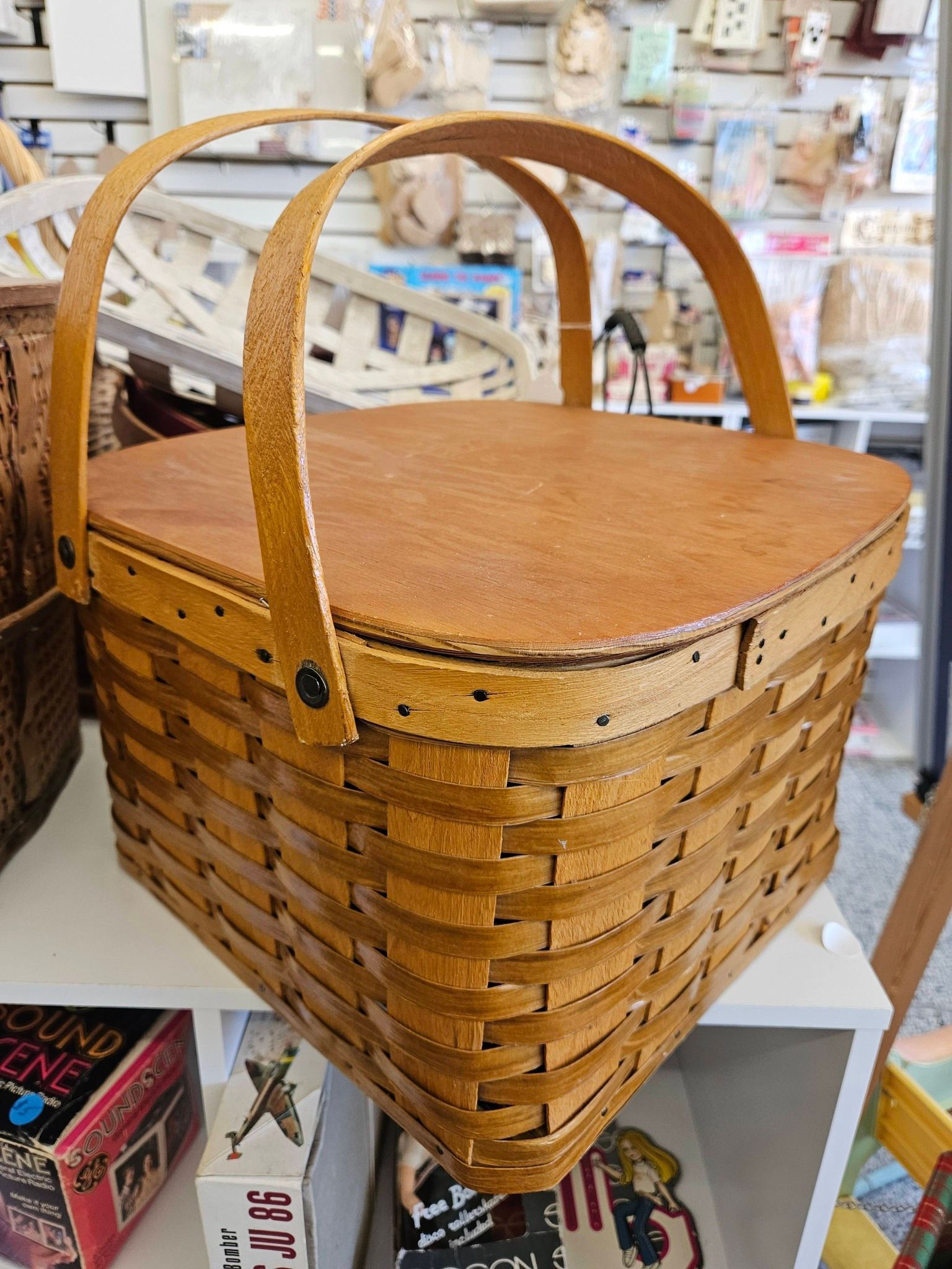 Woven wicker basket with arched handles on a store display shelf
