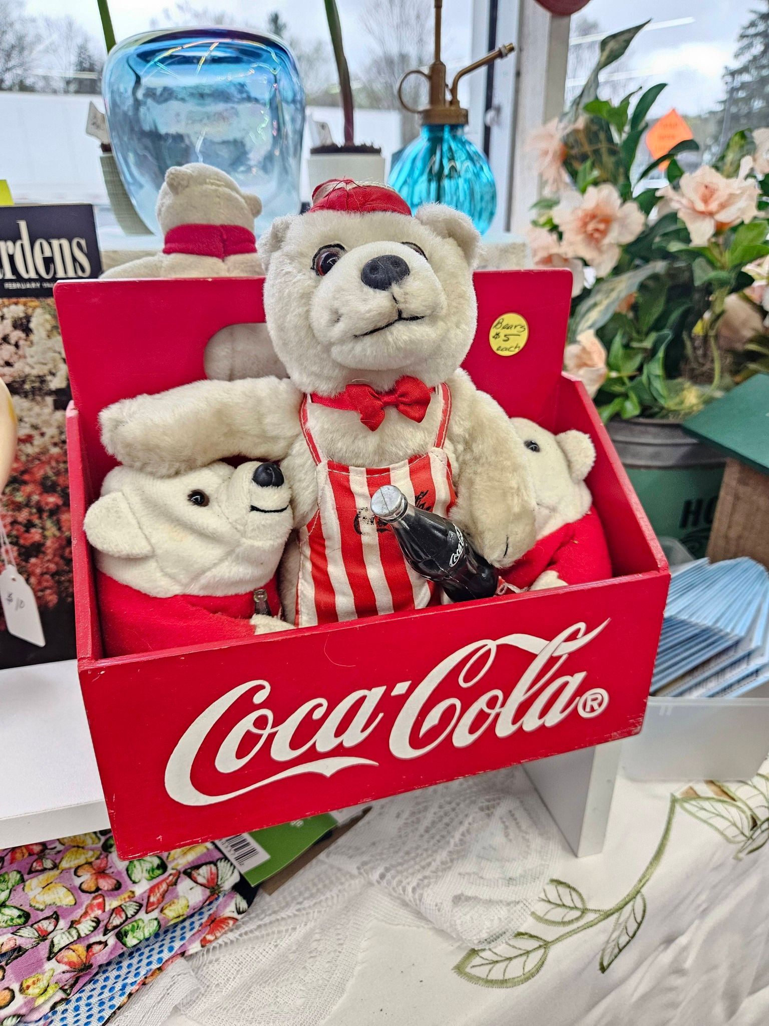 Coca-Cola gift box with two plush teddy bears and holiday decorations on a table