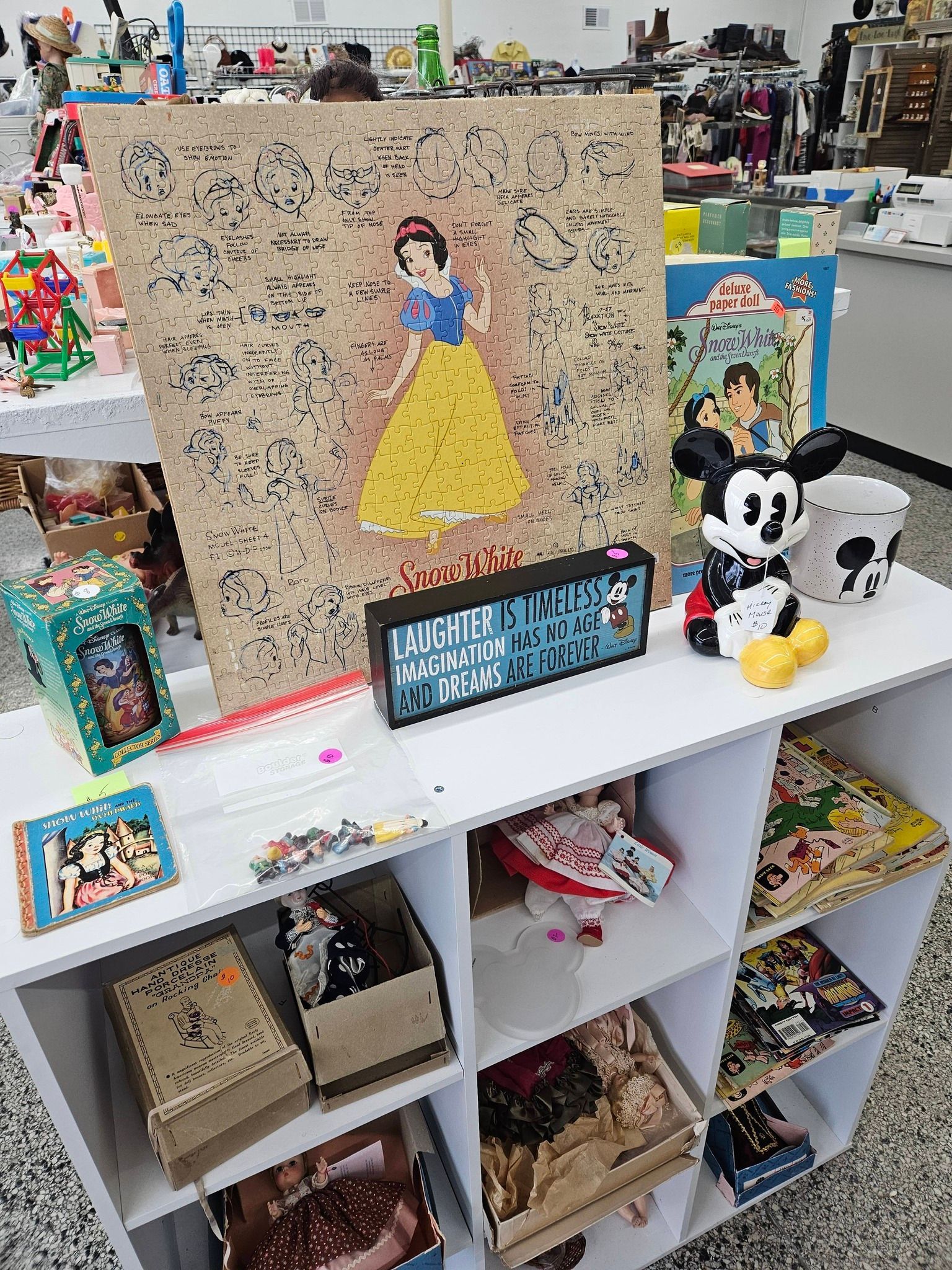 Disney-themed craft display on a white shelf with a Snow White mosaic, Mickey plush, and colorful decorations