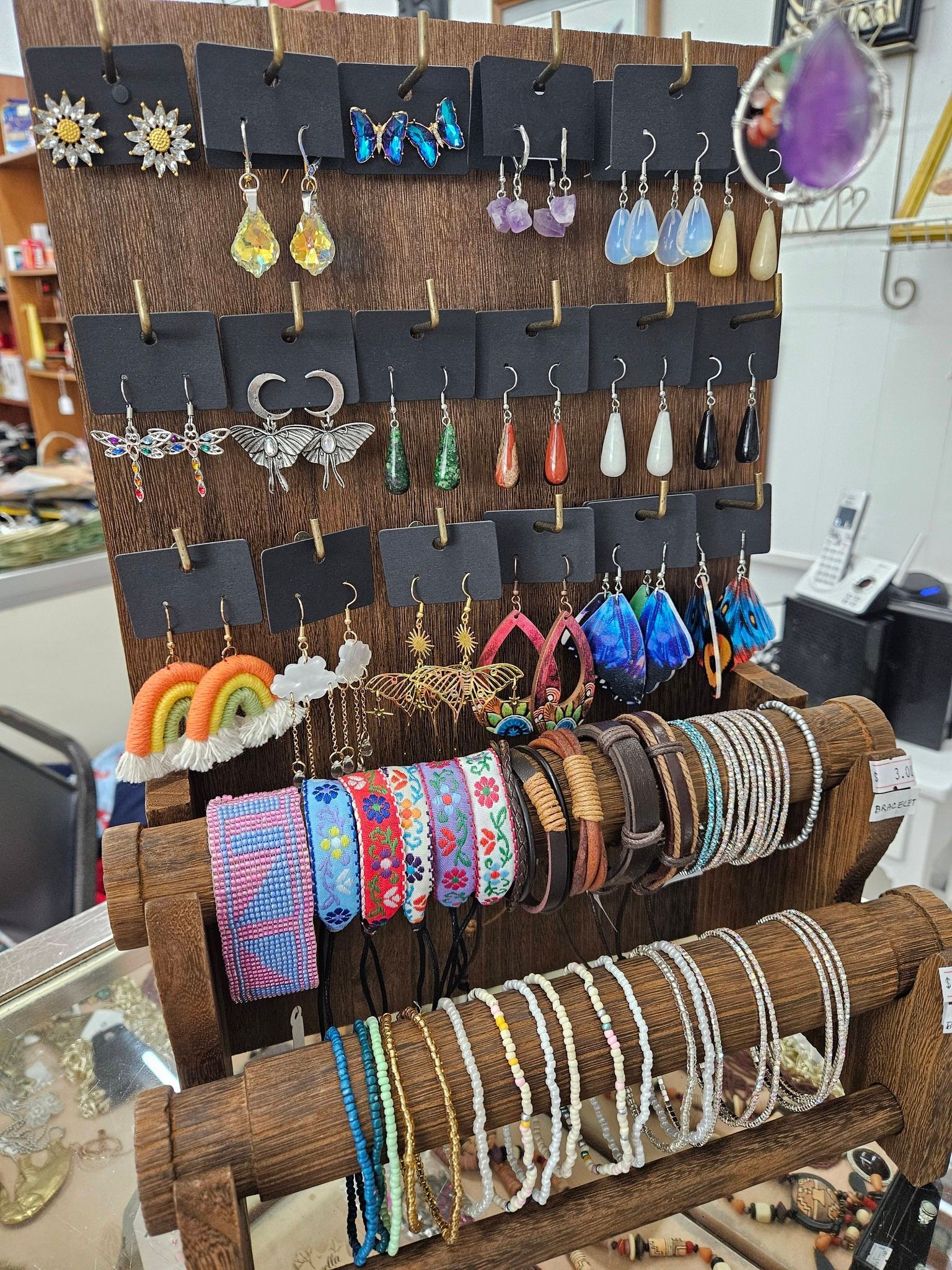 Display of colorful handmade bracelets and earrings on wooden racks in a shop