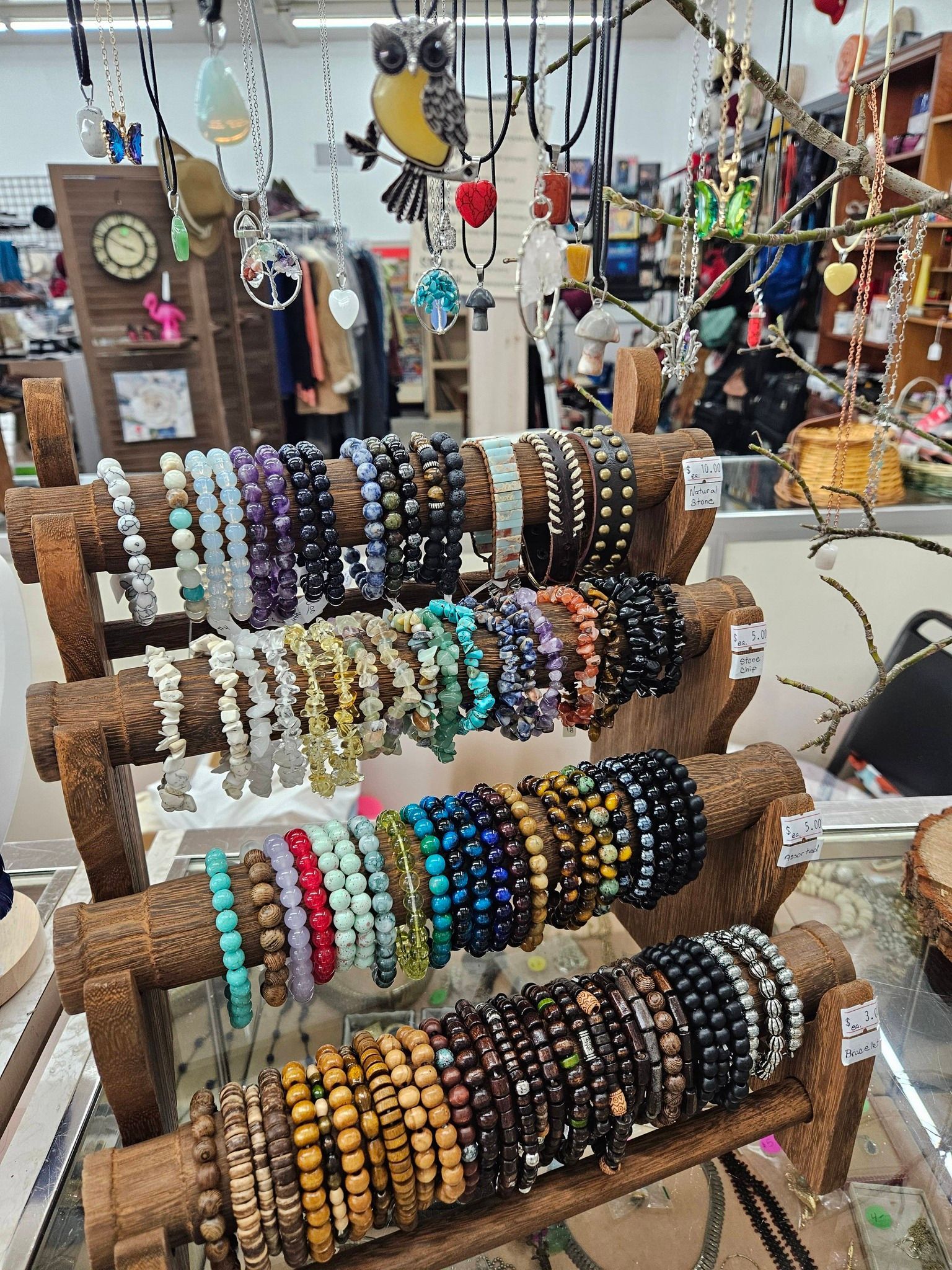 Display of colorful beaded bracelets on wooden stands at a craft market stall
