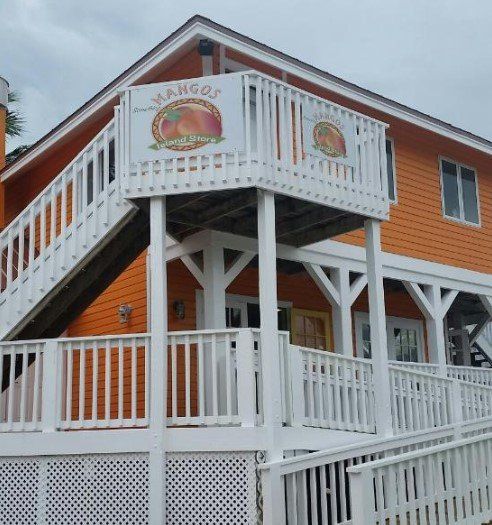 Orange building with white railings, deck, stairs, and 
